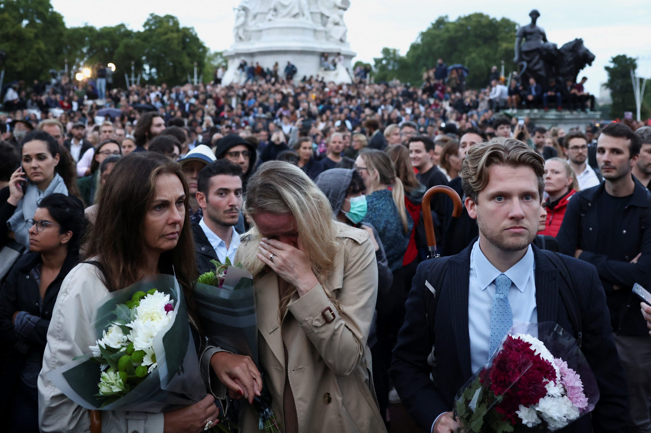 People react outside the Buckingham Palace, after Queen Elizabeth, Britain's longest-reigning monarch and the nation's figurehead for seven decades, died aged 96, according to Buckingham Palace, in London, Britain September 8, 2022. REUTERS/Henry Nicholls