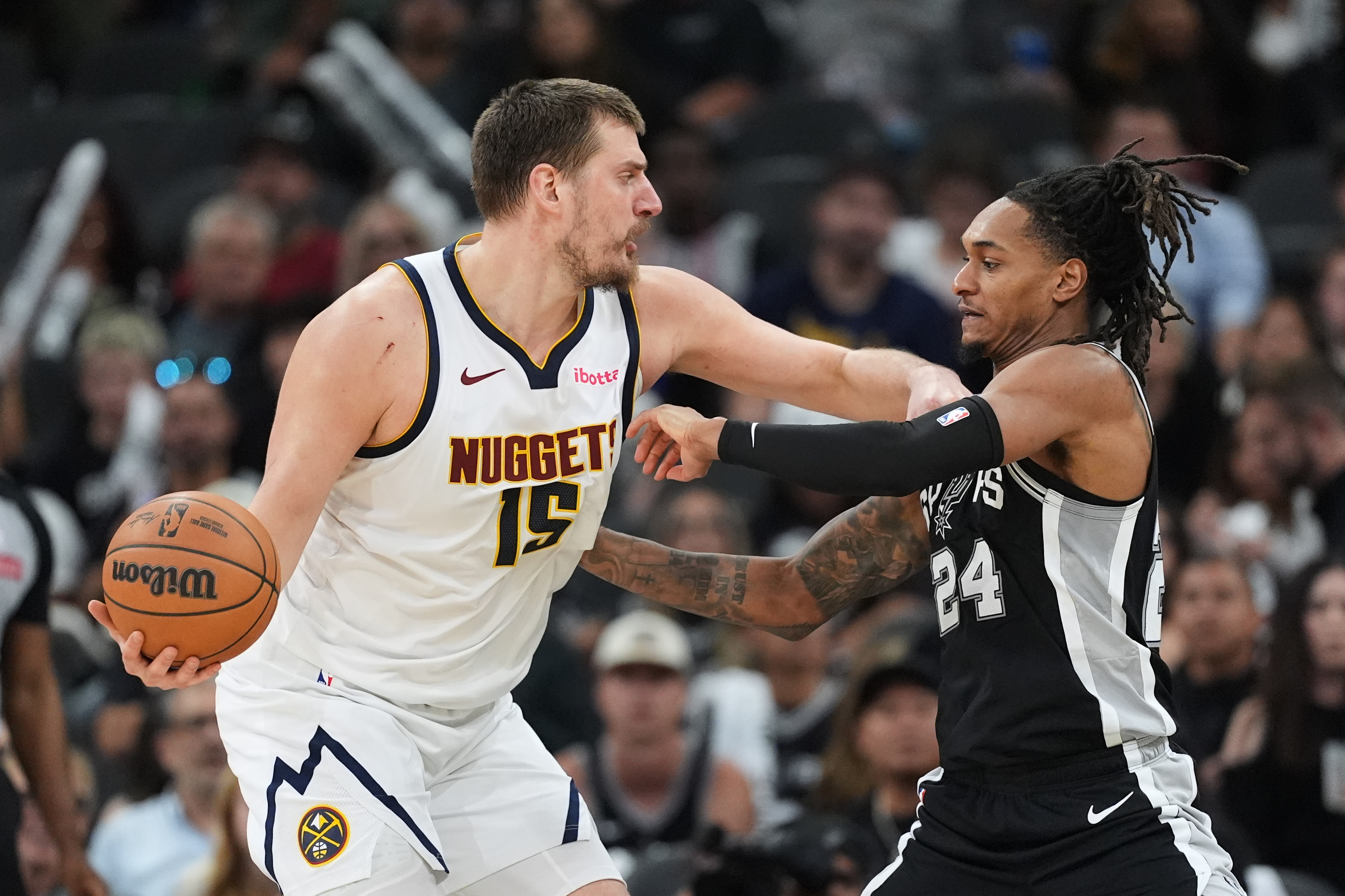 Denver Nuggets center Nikola Jokic (15) is pressured by San Antonio Spurs guard Devin Vassell (24) during the second half of an NBA basketball game in San Antonio, Thursday, March 12, 2026. (AP Photo/Eric Gay)