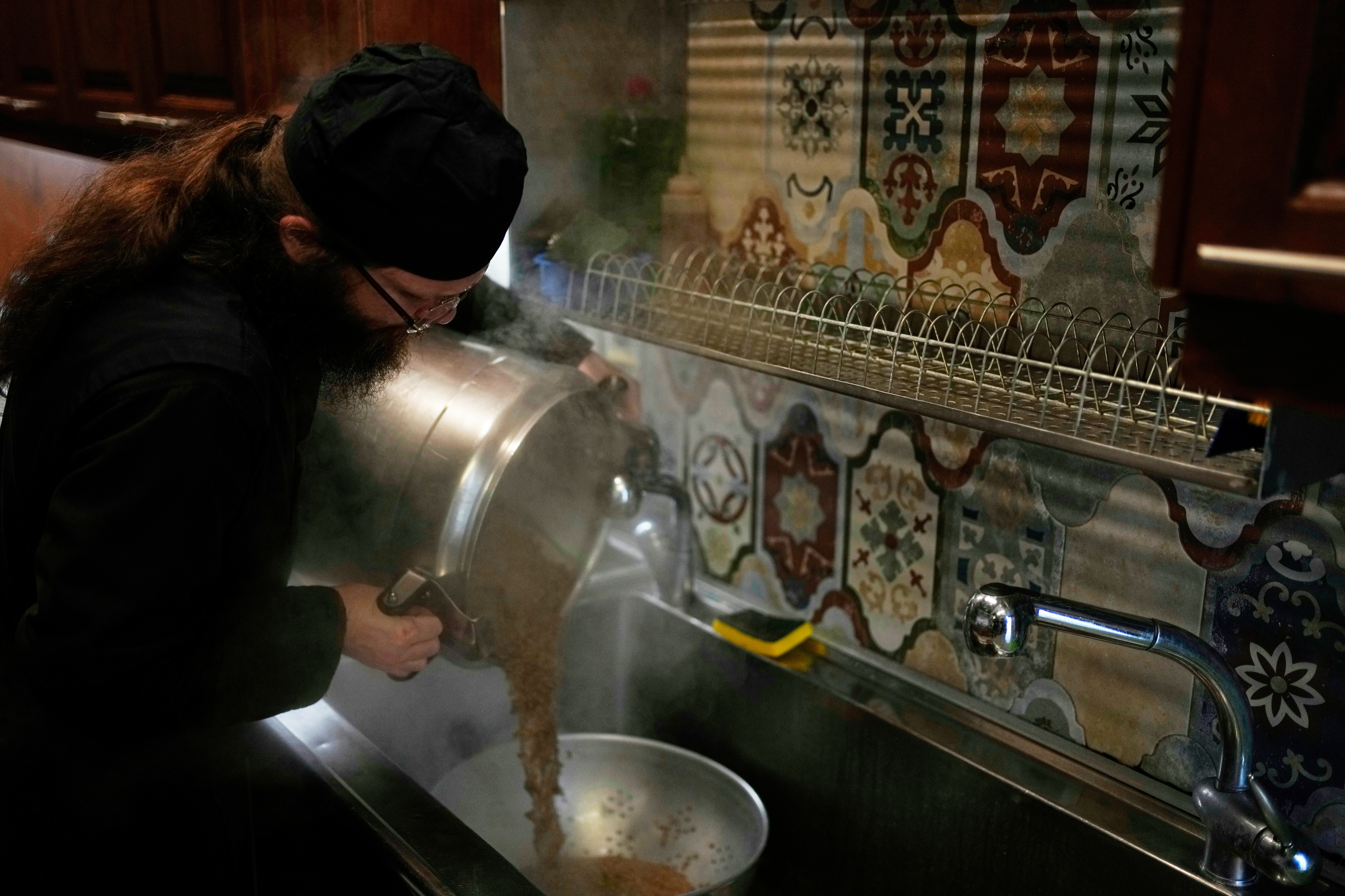 Father Isaac cooks lentils for the midday meal at the Monastery of St. Augustine and Seraphim of Sarov in the village of Trikorfo, about 236 kilometers (147 miles) northwest of Athens, Friday, March 20, 2026. (AP Photo/Thanassis Stavrakis)
