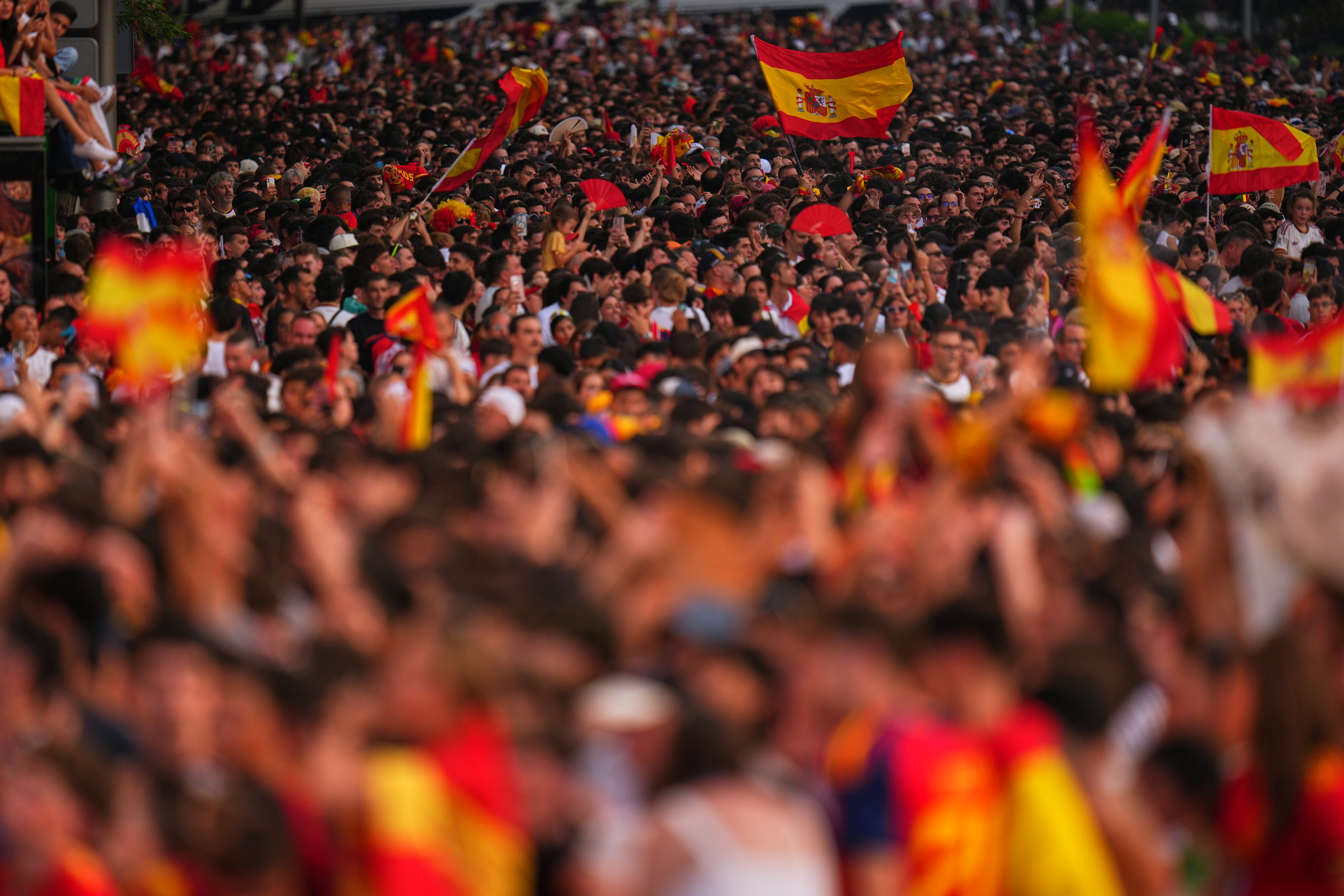 Fans crowd together as they wait for the arrival of players from Spain's national soccer team