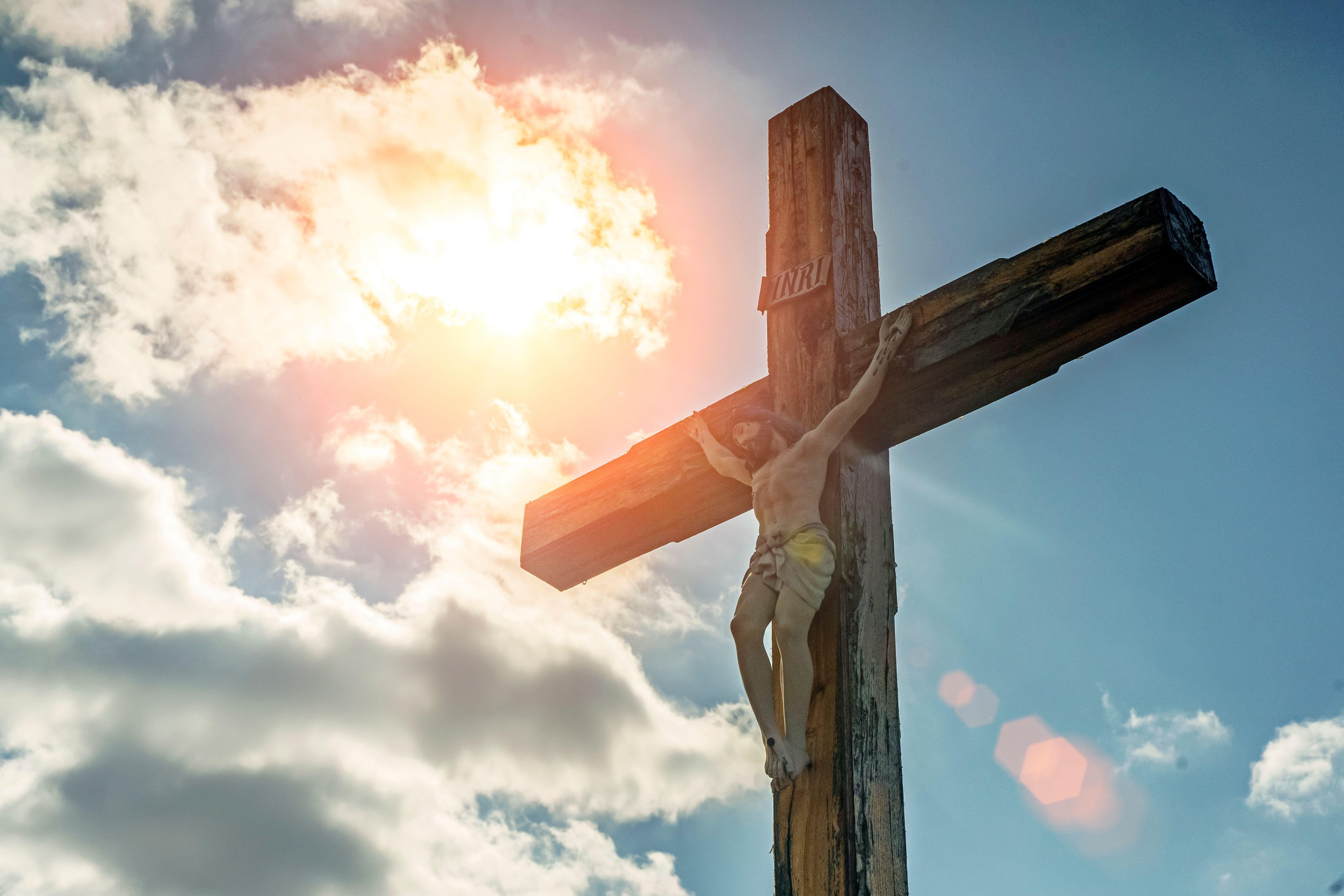 Crucifixion of Christ against the sky background. Catholicism, Christianity, faith concept. The initialism INRI Iesus Nazarenus, Rex Iudaeorum represents the Latin inscription in English translates to Jesus the Nazarene, King of the Jews. High quality pho