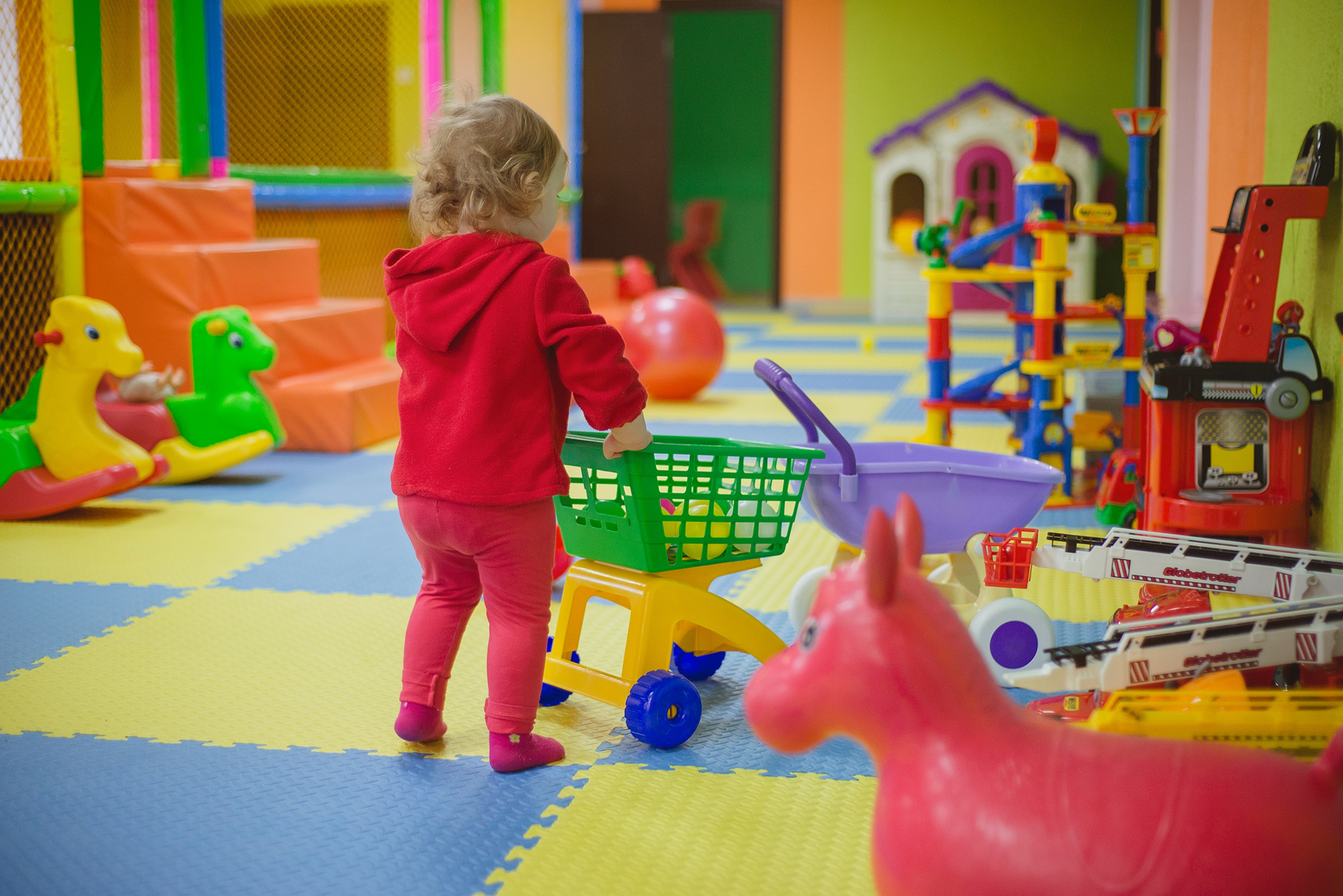 Little,Girl,Playing,In,The,Children's,Playroom,With,Colorful,Balls,