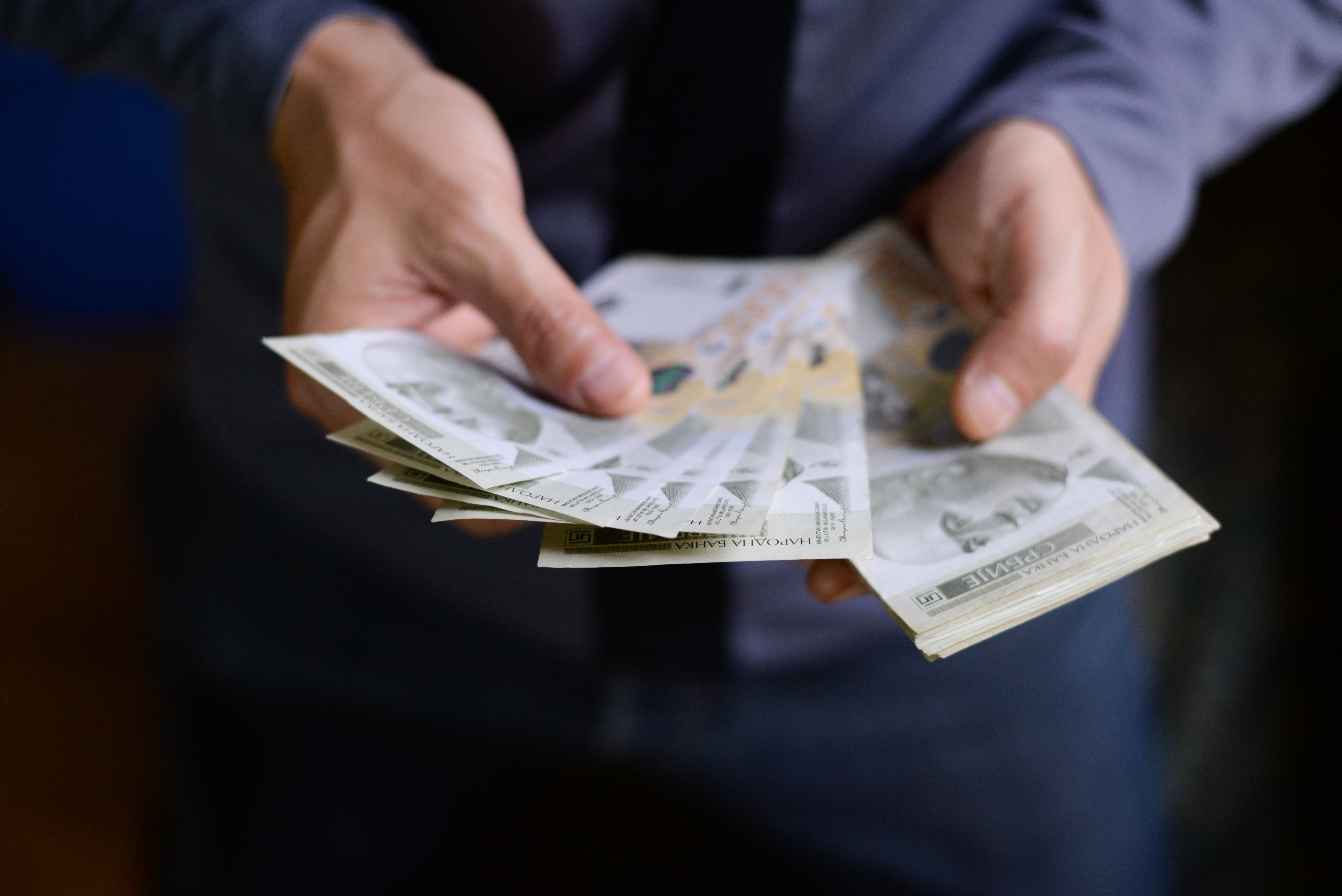 Hands,Holding,Pile,Of,Money.,Serbian,Dinar,Paper,Currency,,2000
