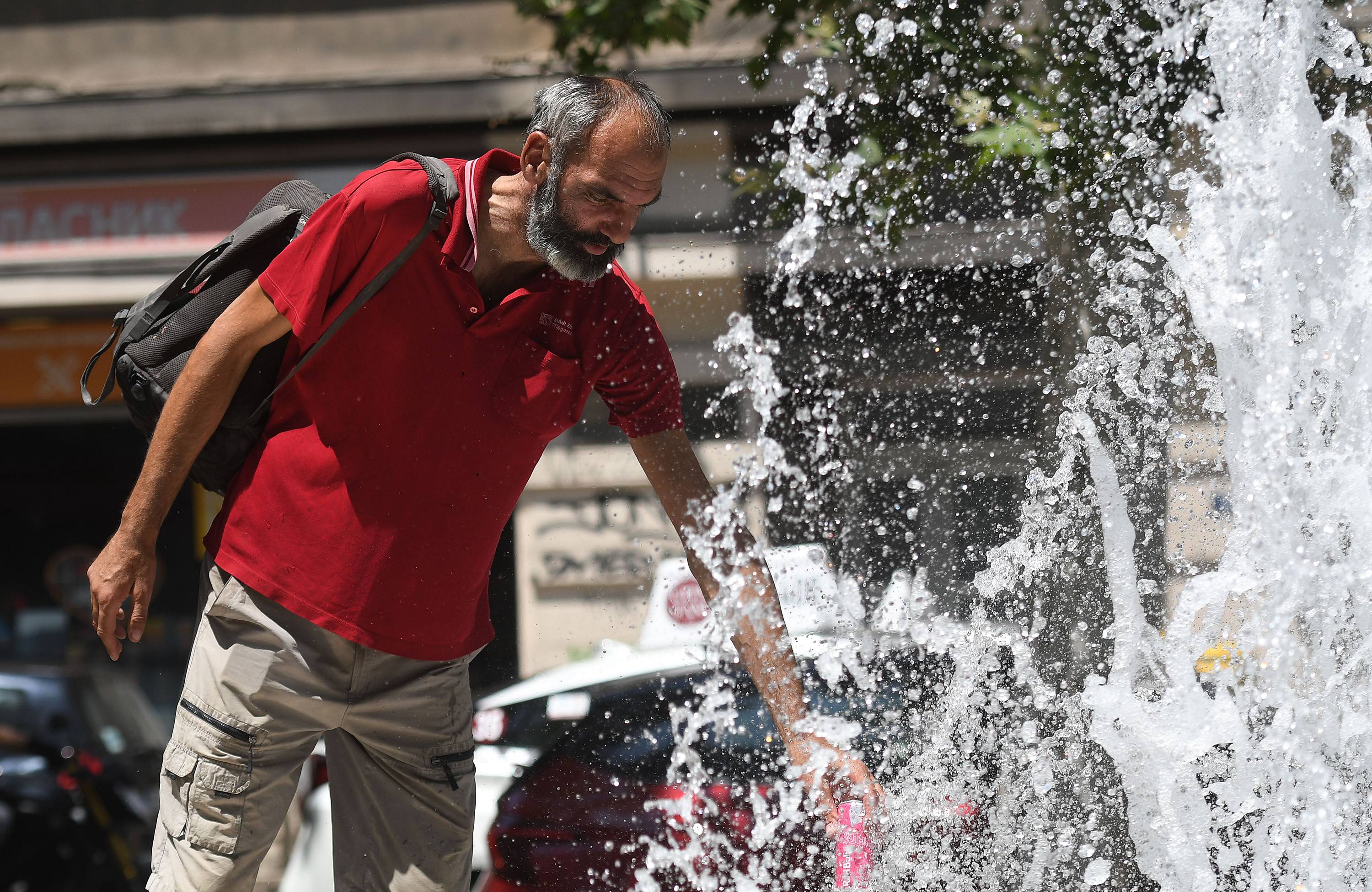 Novi Sad, 23.06.2025. - Covek sa rashladjuje pored fontane u centru Novog Sada. (BETAPHOTO/DRAGAN GOJIC)