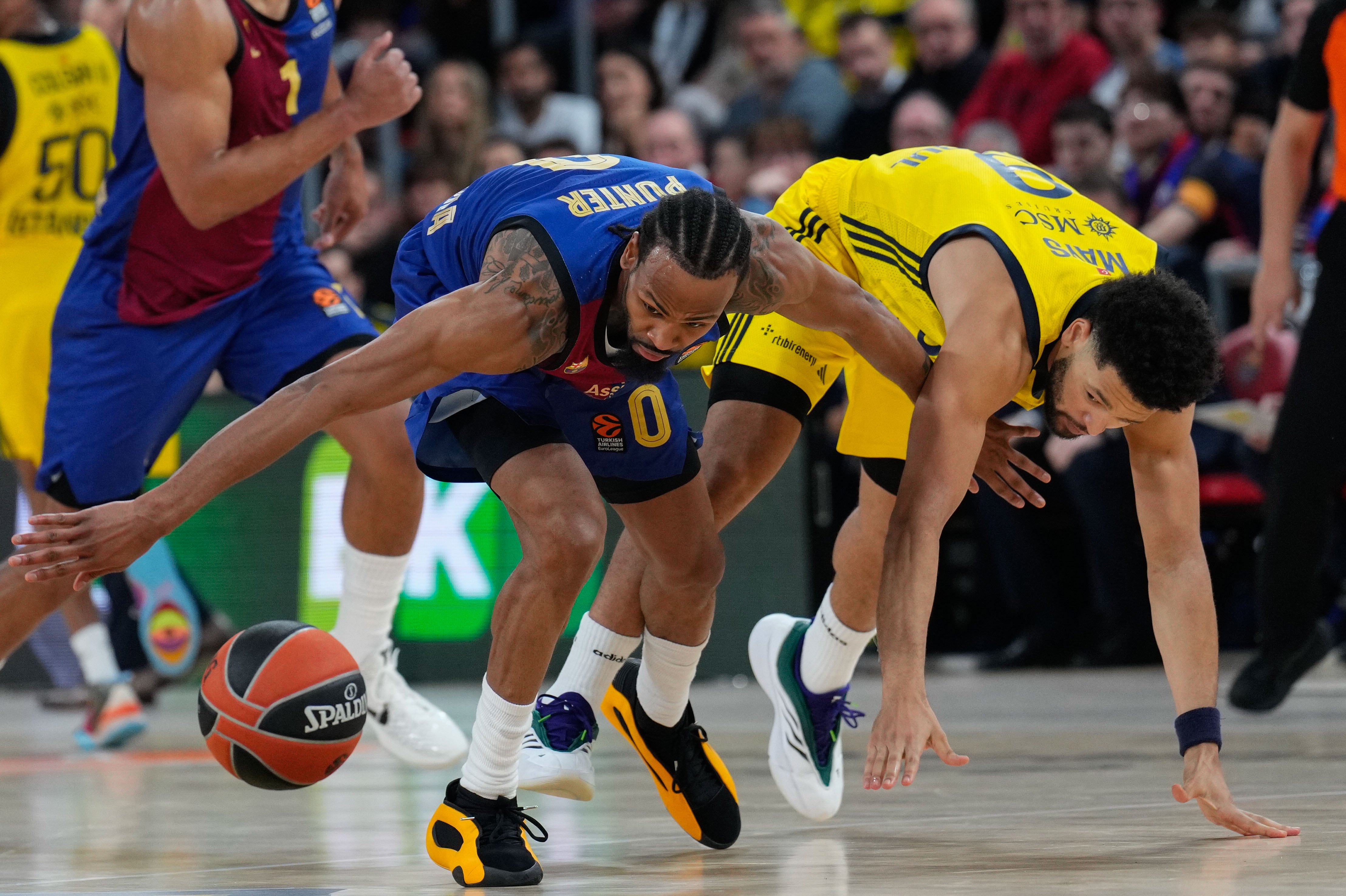 epa11782920 Barcelona's Kevin Punter (L) in action against Fenerbahce's Skylar Mays (R) during the Euroleague basketball match between FC Barcelona and Fenerbahce, in Barcelona, Spain, 17 December 2024.  EPA/Alejandro Garcia