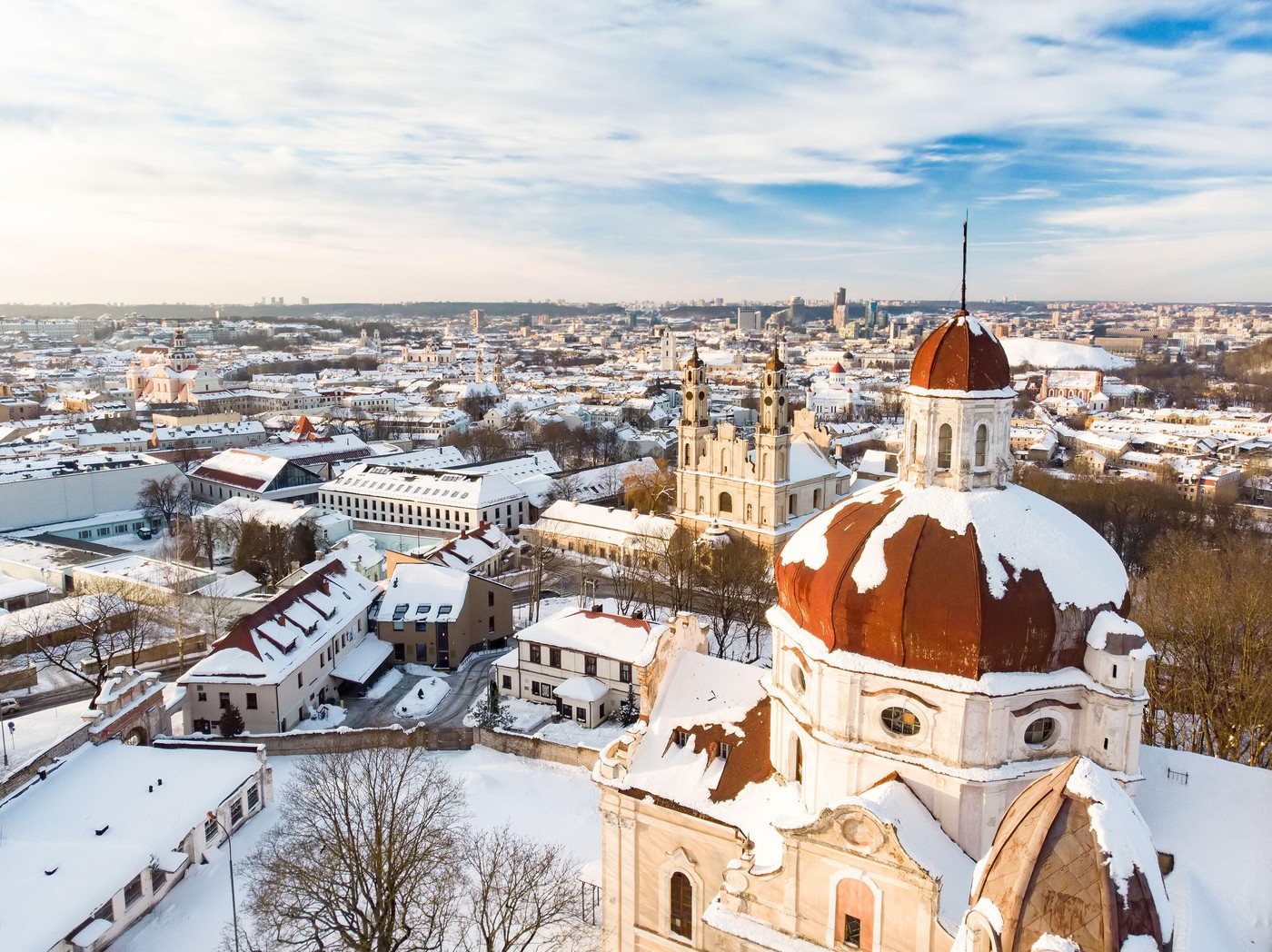 Beautiful Vilnius city panorama in winter with snow covered houses, churches and streets. Aerial evening view. Winter city scenery in Vilnius, Lithuan