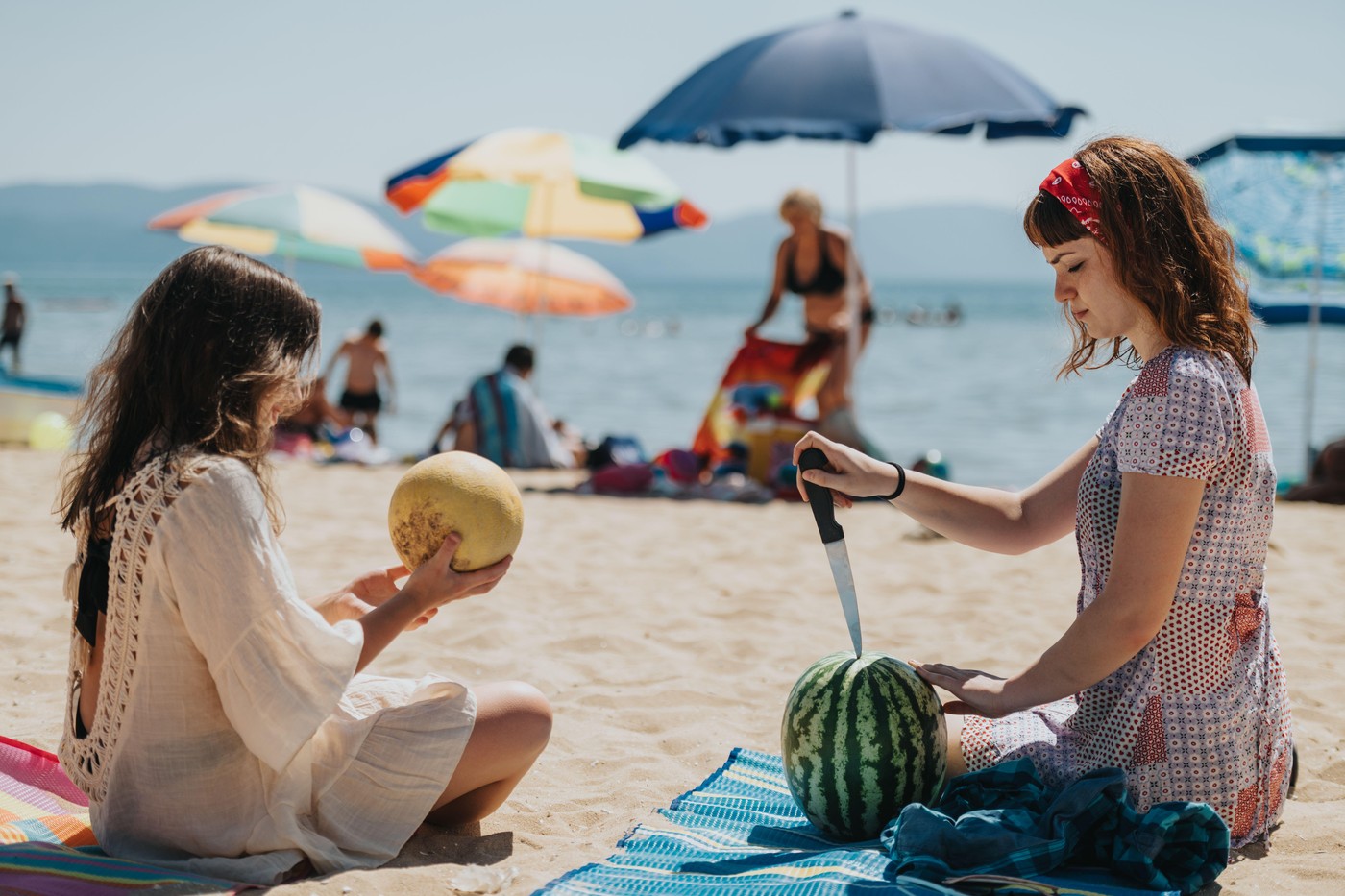 Friends enjoying a sunny day at the beach with fresh fruits