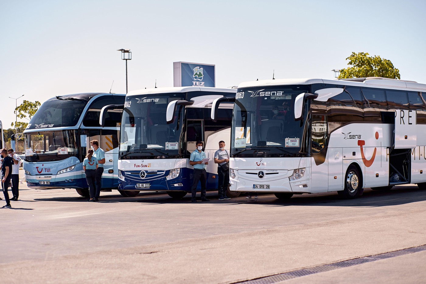 Antalya, Turkey - May 19: Kemer, Turkey - May 19, 05: Tourist modern buses parked at the airport waiting for tourists on a sunny day. People and passengers in masks. Summer vacations starts concept.