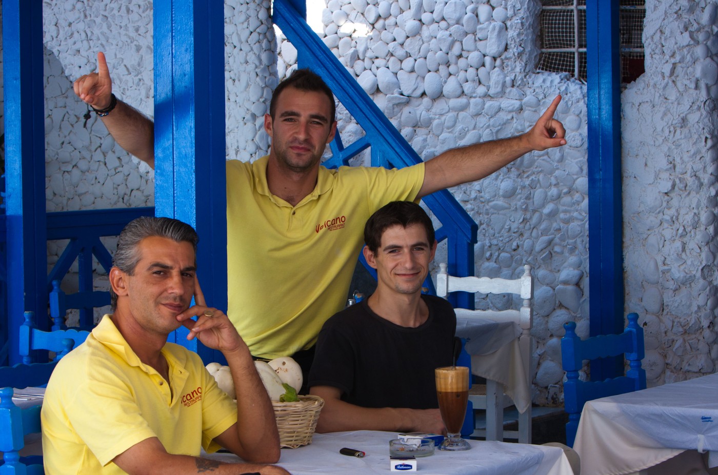 3 greek men greeting the viewer in a restaurant in Thera