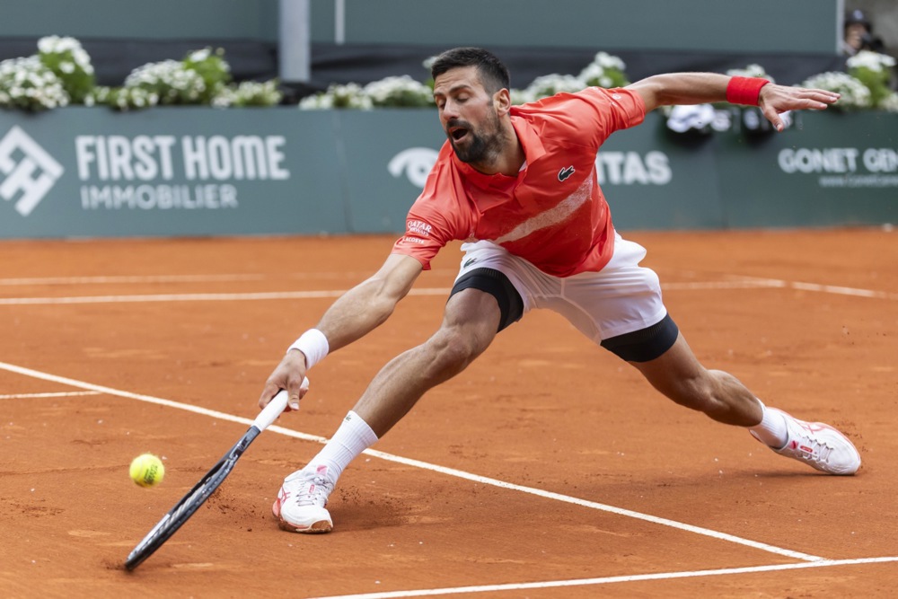 epa12123684 Novak Djokovic, of Serbia, returns a ball to Marton Fucsovics of Hungary, during the round of 16 at the Geneva Open tennis tournament, in Geneva, Switzerland, 21 May 2025.  EPA-EFE/CYRIL ZINGARO