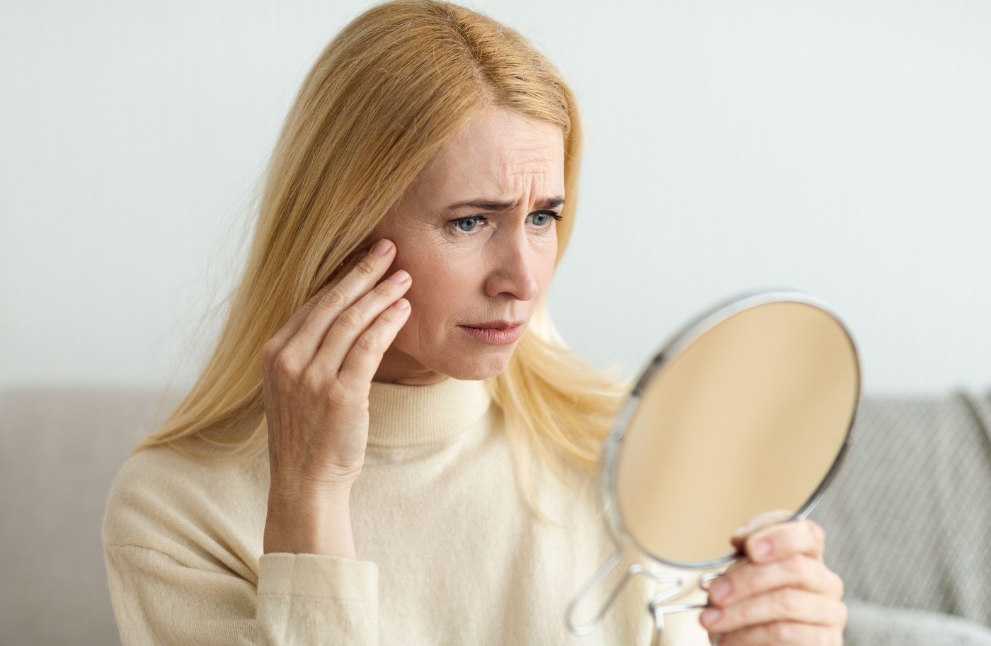 Anti-Wrinkle Skin Care. Sad Woman Looking In Mirror, Touching Her Face,Image: 999722626, License: Royalty-free, Restrictions: , Model Release: no, Credit line: Prostock-studio / Alamy / Profimedia