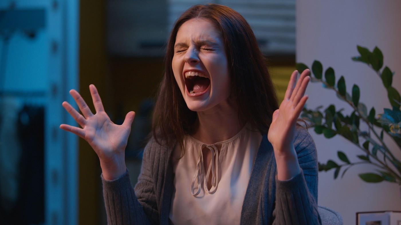 Annoyed woman mad angry Caucasian girl screaming loud at home single female yelling shouting emotional stress insane shout expression furious