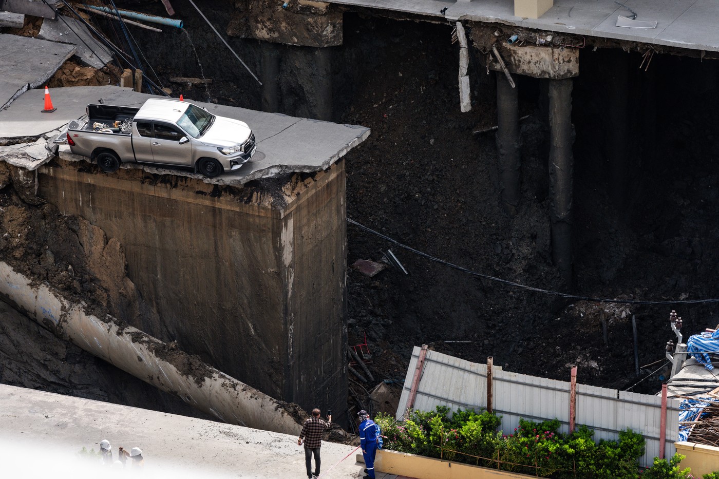 A man takes a photo of a hole in the ground after a road collapsed near a hospital in Bangkok on September 24, 2025.,Image: 1039734414, License: Rights-managed, Restrictions: , Model Release: no, Credit line: Chanakarn Laosarakham / AFP / Profimedia