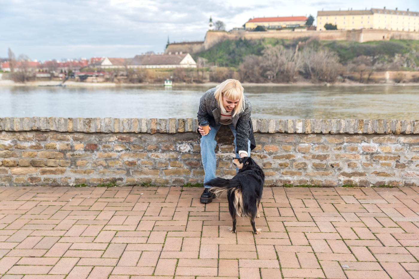 Young woman pet owner spending quality time with her adopted rescued dog outdoor walking and enjoying their friendship. Hipster female with cool attit