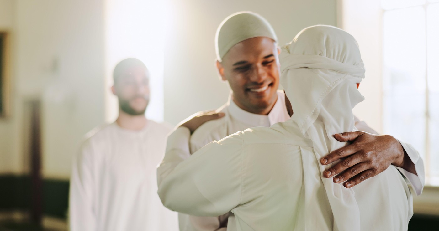 Muslim, happy and people in mosque, hug and worship for Islamic religion, Ramadan and faith in morning. Fajr, praise and men with respect for Allah