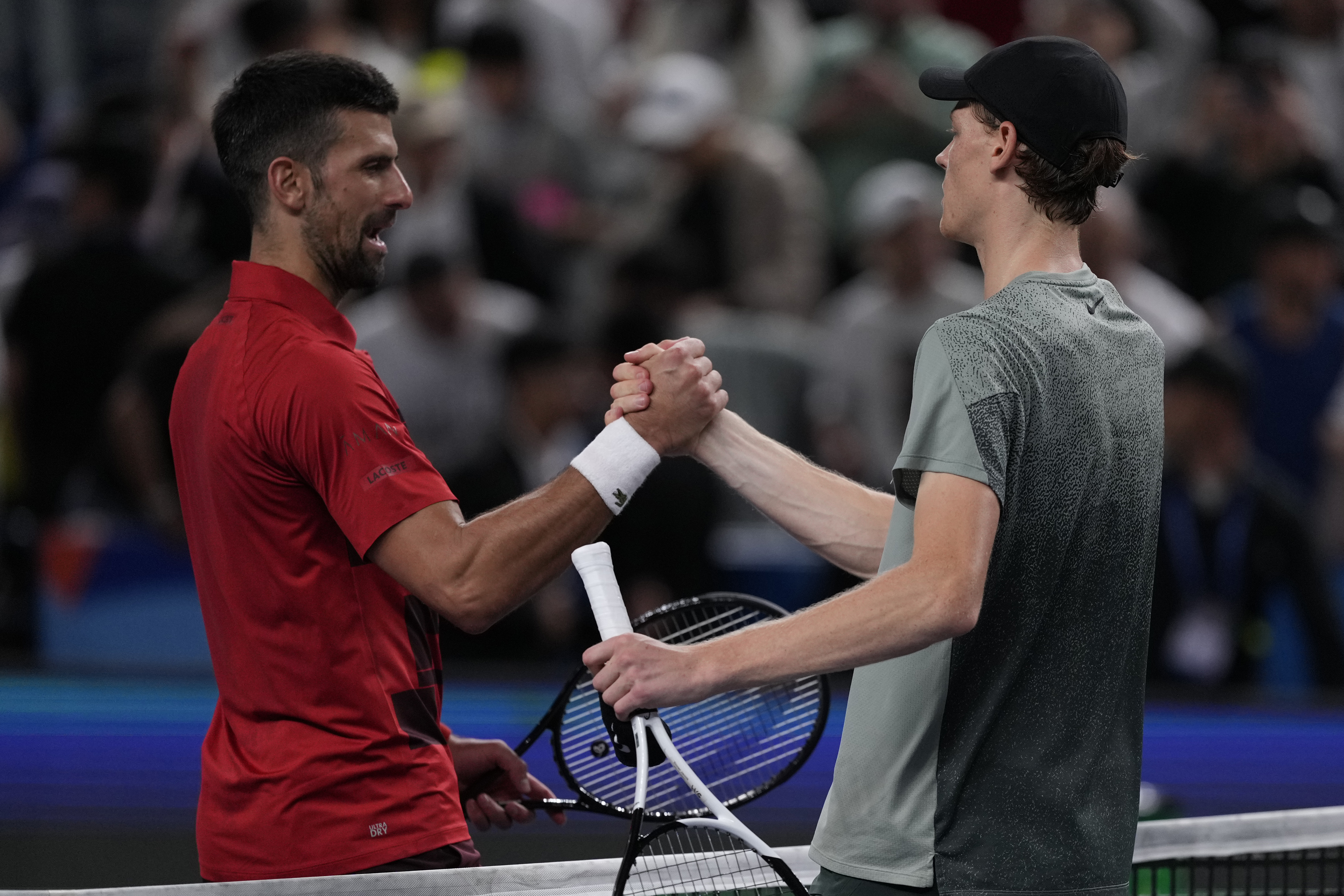 Jannik Sinner of Italy right clasp hands Novak Djokovic of Serbia after their men's singles finals match for the Shanghai Masters tennis tournament at Qizhong Forest Sports City Tennis Center in Shanghai, China, Sunday, Oct. 13, 2024. (AP Photo/Andy Wong)