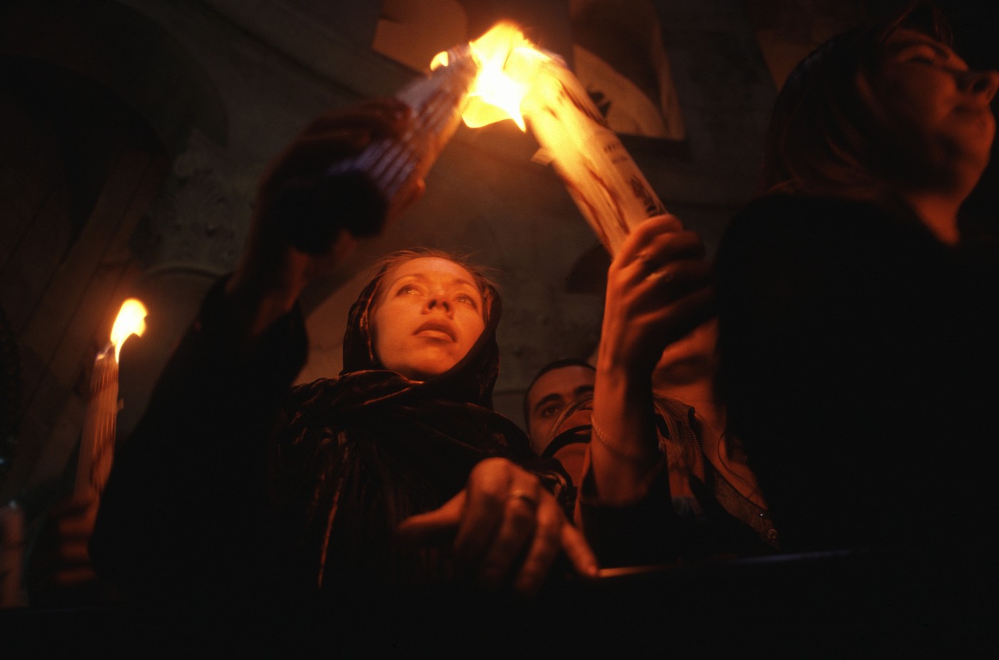 Christian Orthodox worshiper holds up candles lit from the Holy Fire during Holy Saturday inside the Church of Holy Sepulchre in the old city of Jerusalem Israel. The Holy Fire is described by Orthodox Christians as a miracle that occurs every year at the