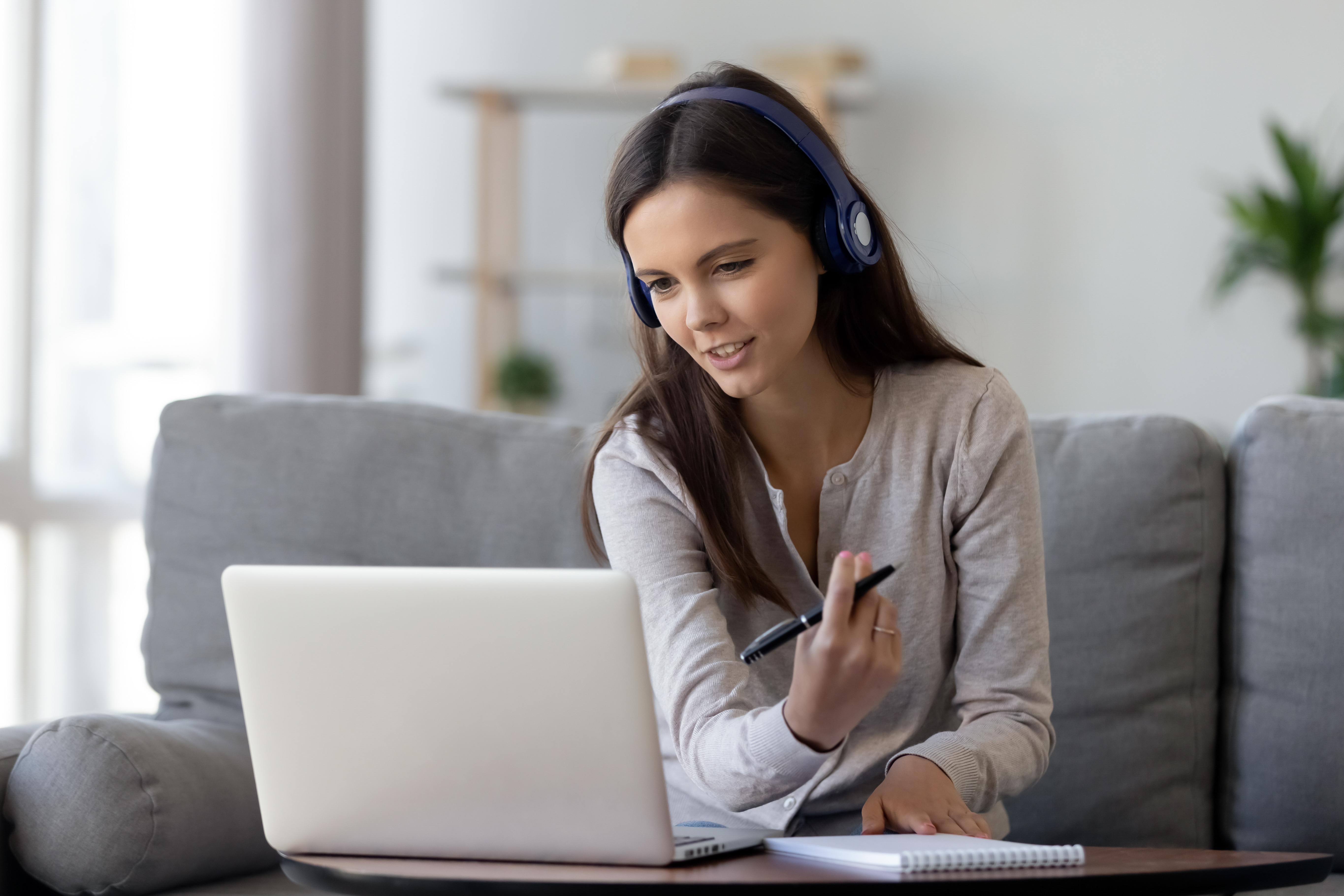 Happy,Young,Woman,In,Headphones,Speaking,Looking,At,Laptop,Making