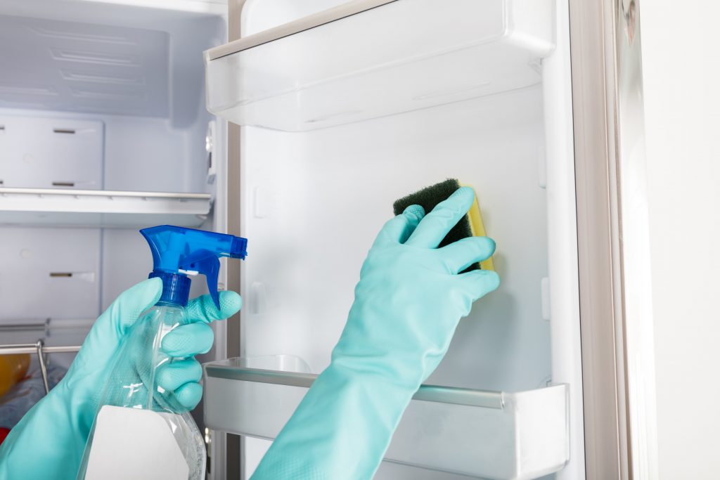 Close-up Of Person Hand Cleaning Refrigerator With Spray Bottle And Sponge,Image: 335550546, License: Royalty-free, Restrictions: , Model Release: no, Credit line: Andriy Popov / Panthermedia / Profimedia