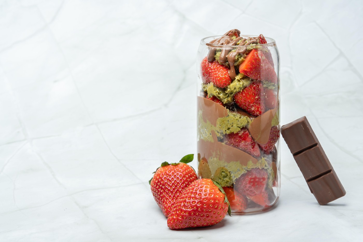 Popular Dubai chocolate strawberry cup with kunafa, pistachio paste, tahini, milk chocolate and fresh strawberries. Decorated with strawberries and