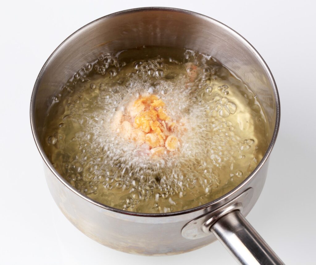 Chicken drumstick coated in corn flakes being deep fried,Image: 90026624, License: Rights-managed, Restrictions: , Model Release: no, Credit line: Afis / Digifoodstock / Profimedia