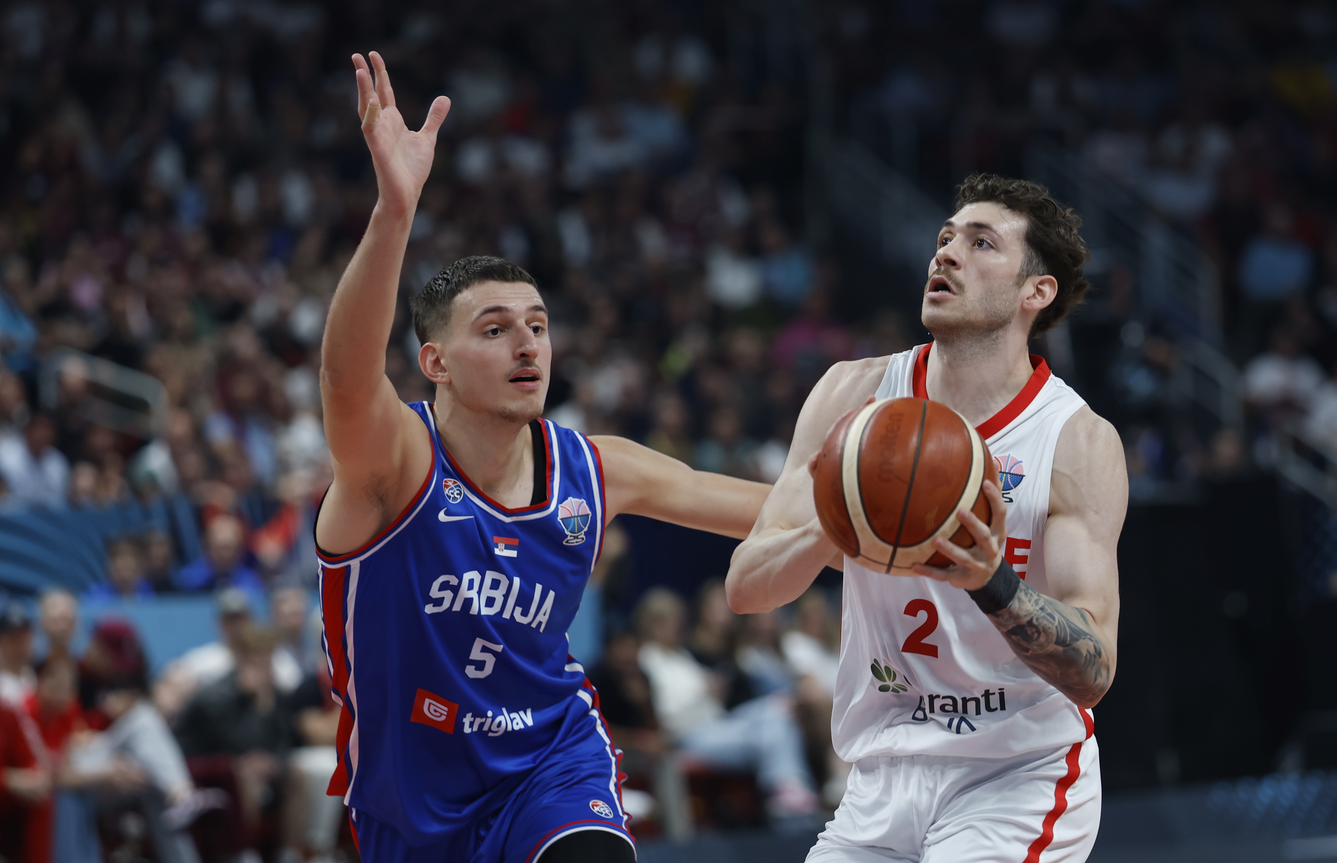 epa12350139 Sehmus Hazer (R) of Turkey and Nikola Jovic of Serbia in action during the EuroBasket 2025 group A basketball match between Turkey and Serbia in Riga, Latvia, 03 September 2025.  EPA/TOMS KALNINS