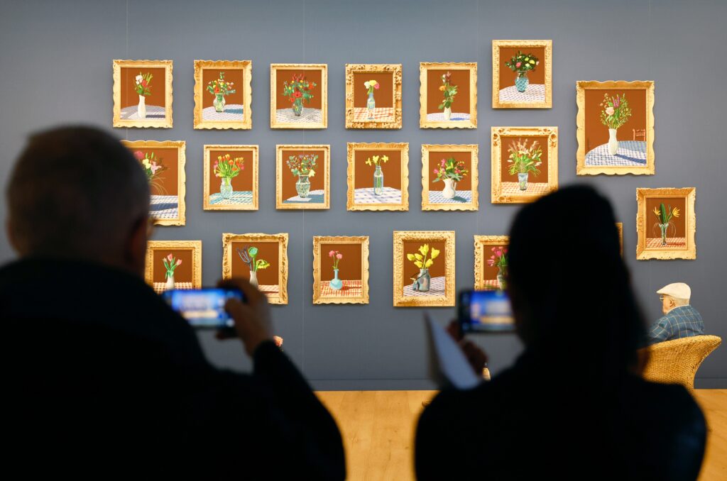 epa12017511 Visitors record artworks by English artist David Hockney as part of the 'David Hockney 25' exhibition at Fondation Louis Vuitton in Paris, France, 08 April 2025. The exhibition runs from 09 April until 31 August 2025.  EPA-EFE/MOHAMMED BADRA