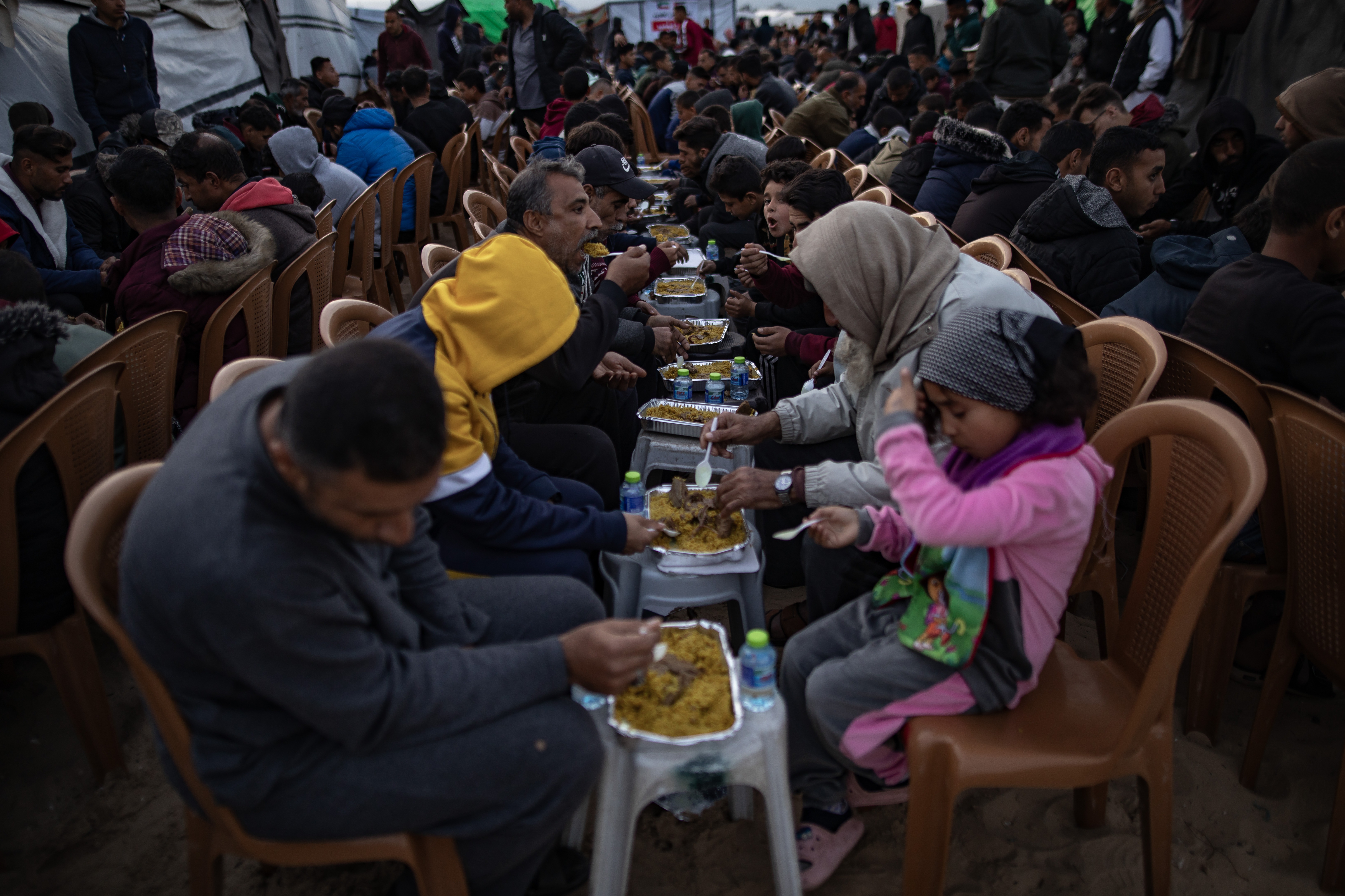 epa11940254 Palestinians gather near their tents to break their fast together on the fourth day of the holy month of Ramadan in Khan Younis, southern Gaza Strip, 04 March 2025.  EPA-EFE/HAITHAM IMAD
