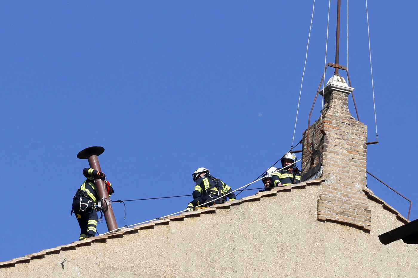 Vatican firefighters set up the chimney atop the Sistine Chapel for the upcoming Conclave