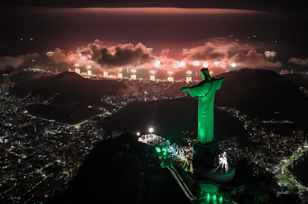 epa11800718 An aerial photograph shows a fireworks display held with the Christ the Redeemer Monument in the foreground during New Year celebrations, at Copacabana beach, in Rio de Janeiro, Brazil, 01 January 2025.  EPA-EFE/Antonio Lacerda