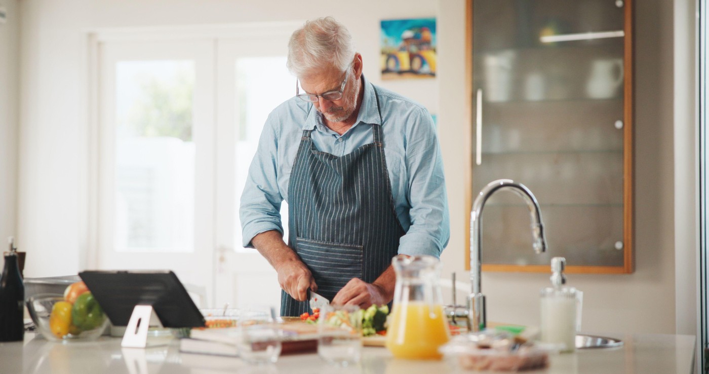 Mature man, tablet and meal prep with recipe tutorial, method or online guide in home. Learning, instructions and person in kitchen with lunch