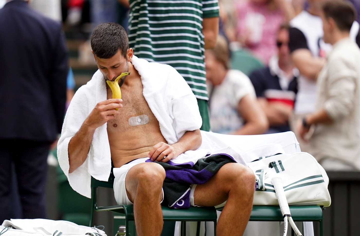Novak Djokovic eating a banana during the gentlemen's quarter final match against Andrey Rublev on day nine of the 2023 Wimbledon Championships at the All England Lawn Tennis and Croquet Club in Wimbledon. Picture date: Tuesday July 11, 2023.
