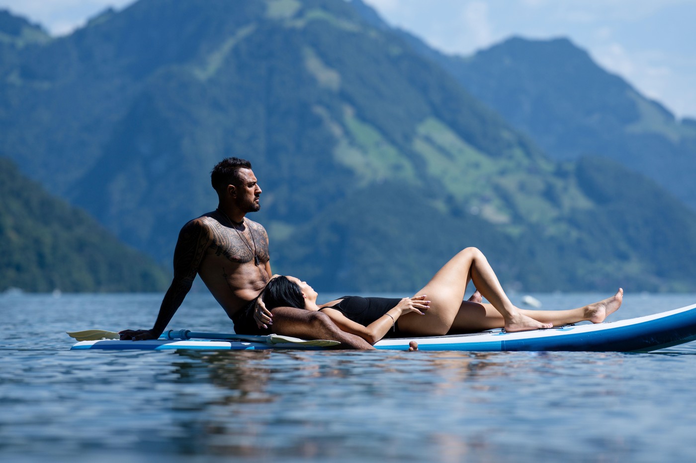 Couple rest relax in Alps lake. Beach and summer vacation. Sexy couple rest relax. Sexy couples resting and relaxing. Love summer holiday. Sensual