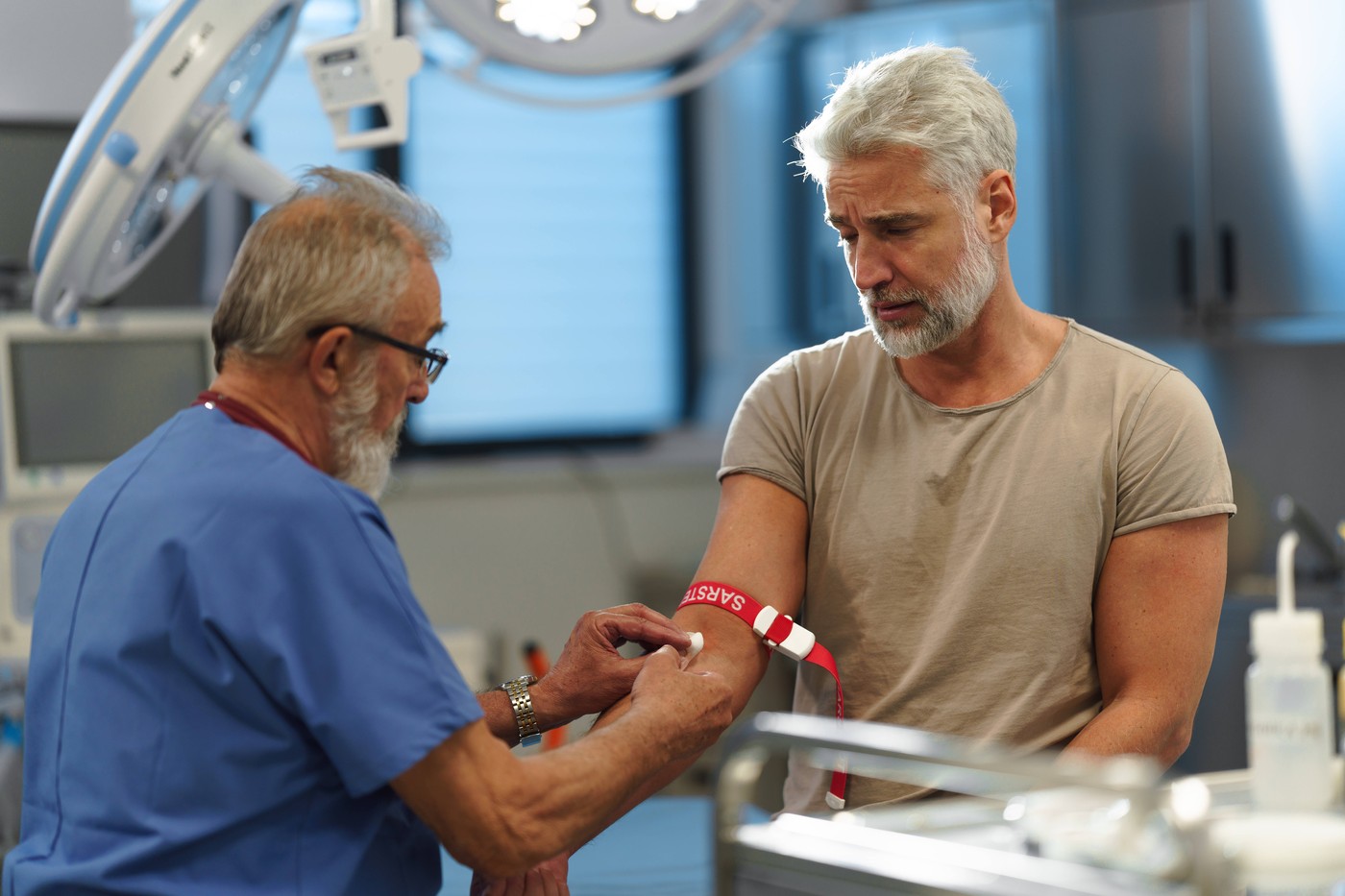 Doctor drawing blood from patient's arm.