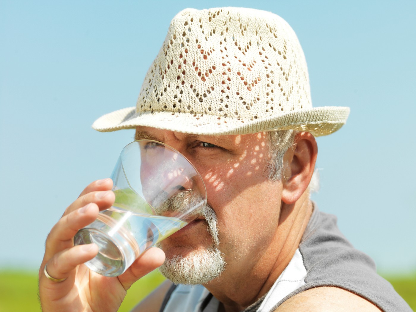 Older man drinking water outdoors