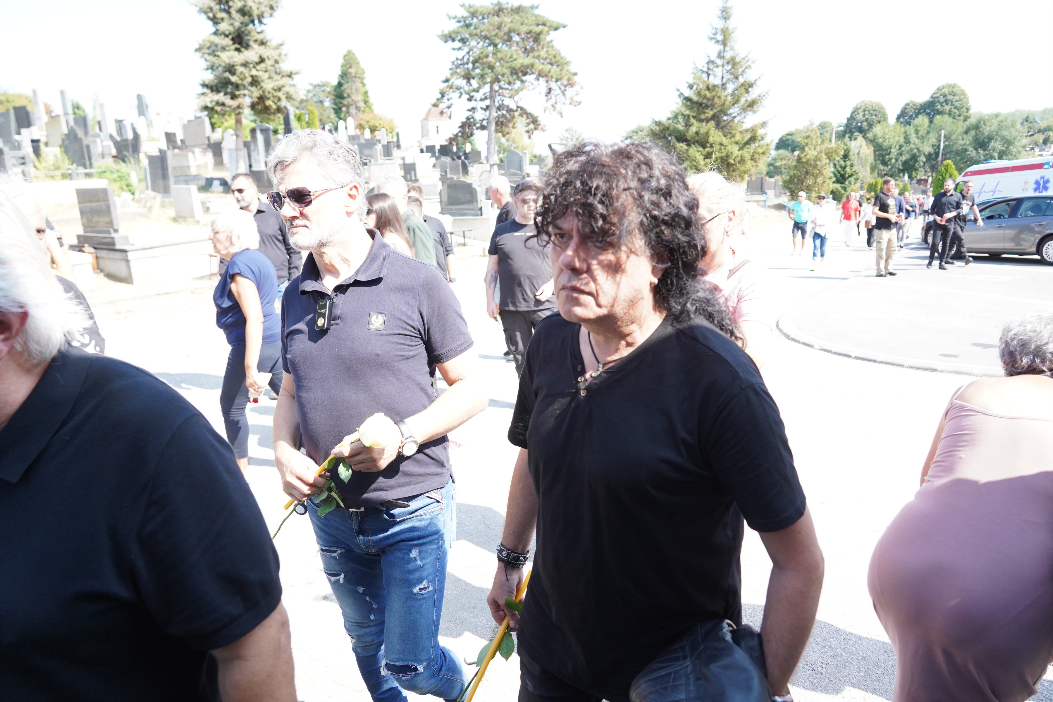 In front of the chapel at the City Cemetery in Cacko, there is a chest with Bora's body, and wreaths with farewell messages are placed around it.
