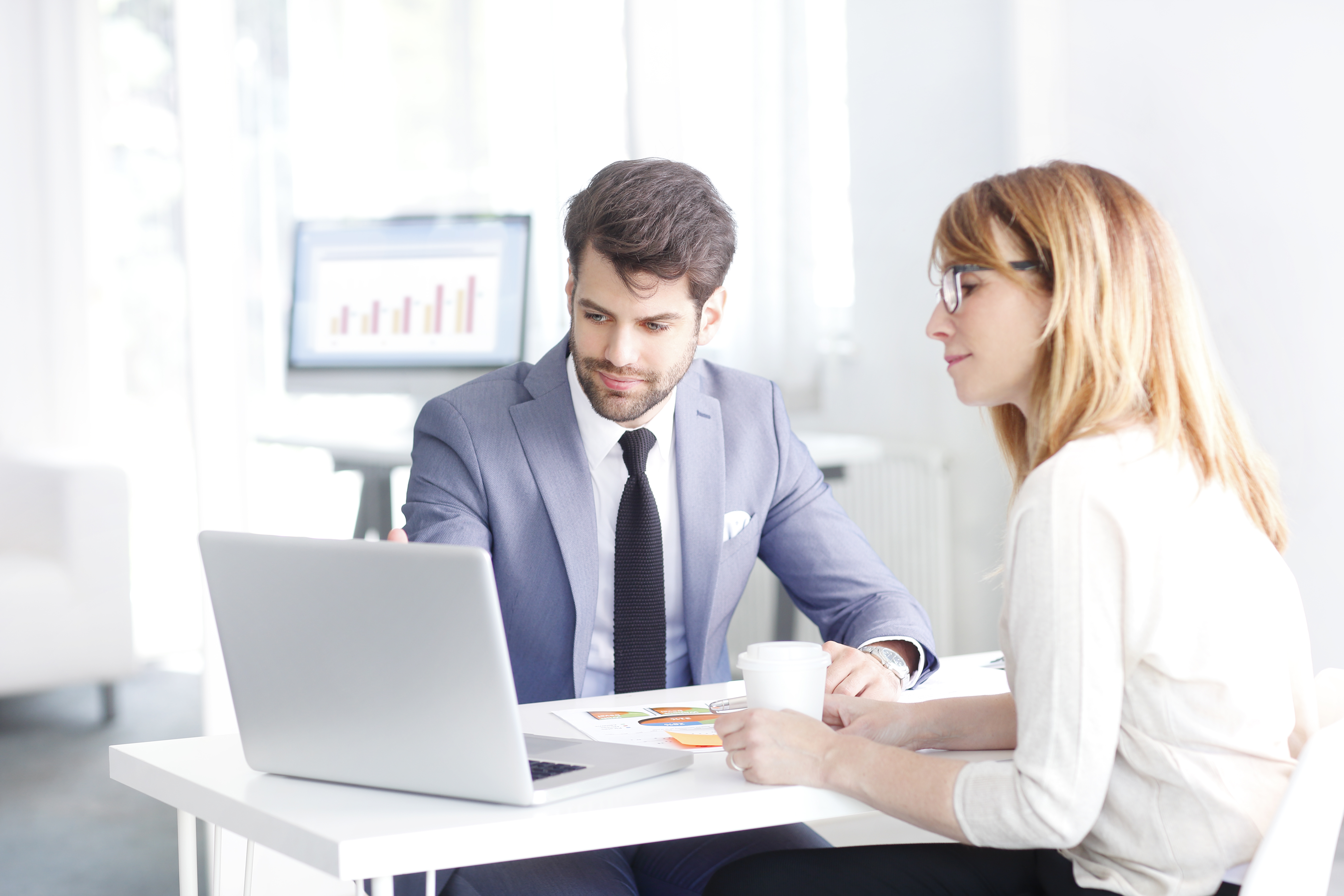 Portrait,Of,Young,Bank,Officer,Consulting,With,Businesswoman,While,Sitting