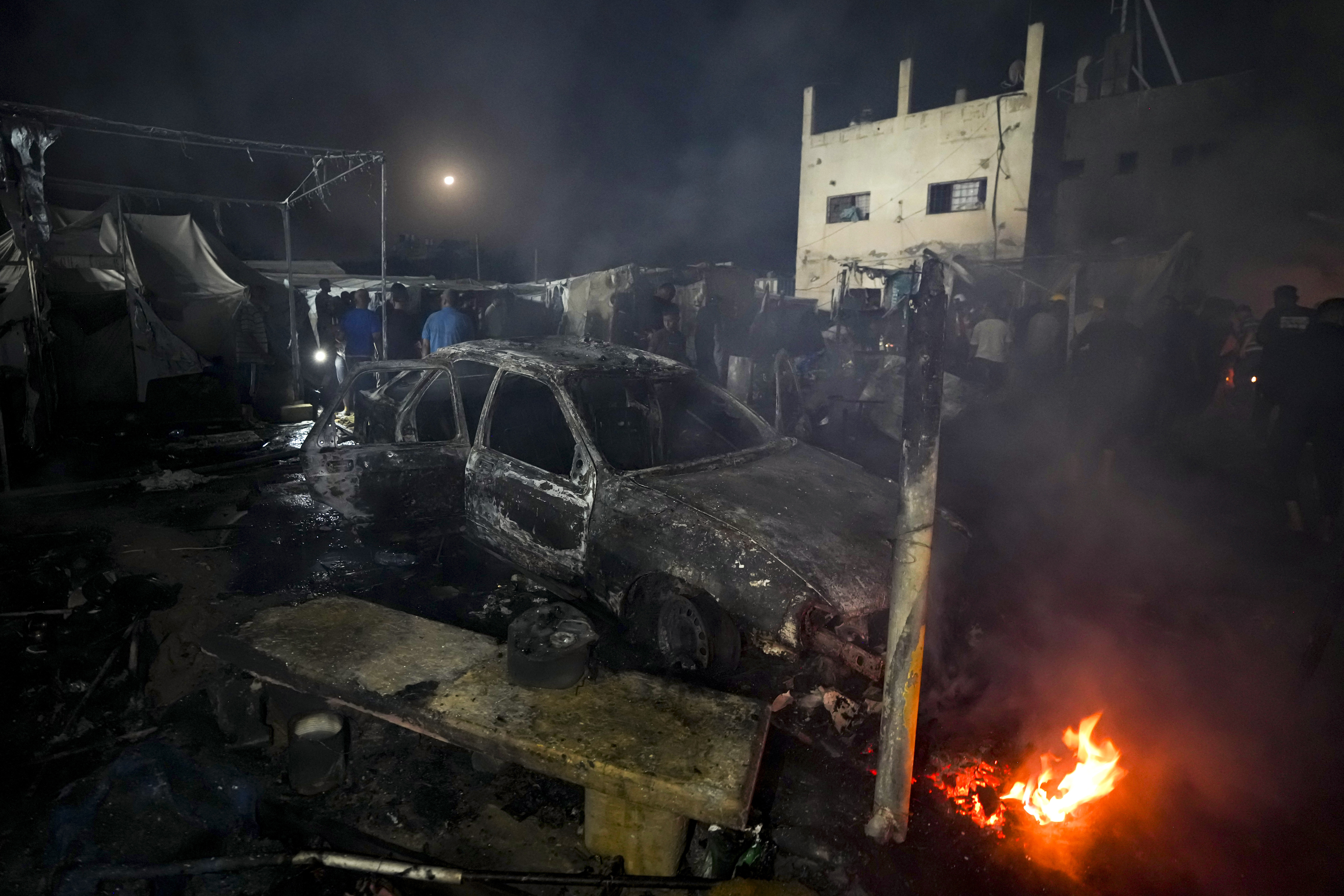 Palestinians inspect the damage at a tent area in the courtyard of Al Aqsa Martyrs hospital, hit by an Israeli bombardment on Deir al-Balah, central Gaza Strip, Monday, Oct. 14, 2024. (AP Photo/Abdel Kareem Hana)