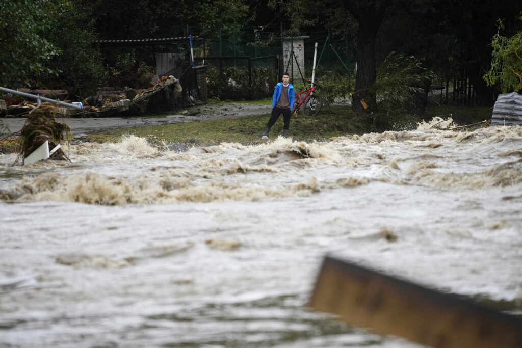A resident looks at the river during floods in Jesenik, Czech Republic, Sunday, Sept. 15, 2024. (AP Photo/Petr David Josek)