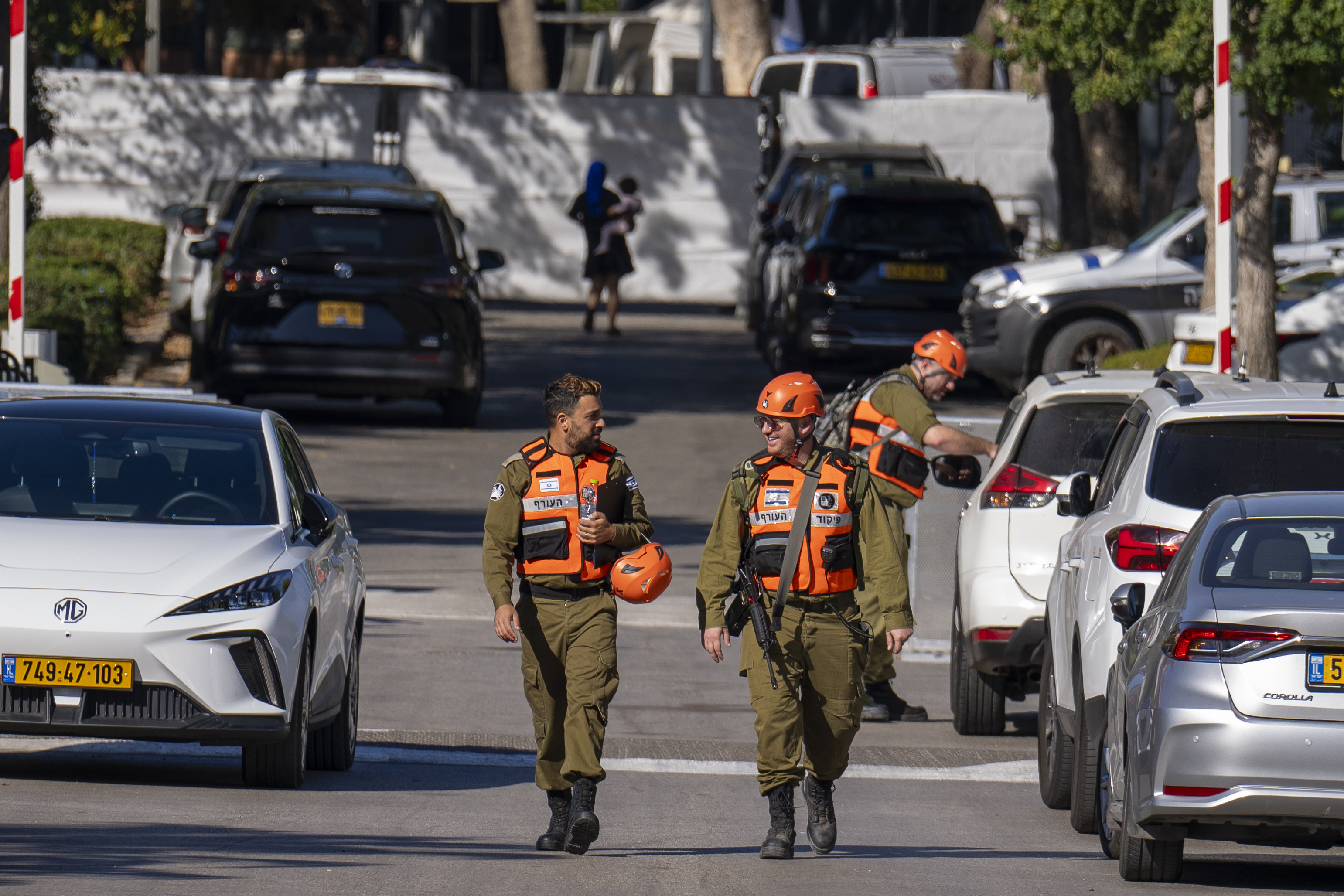 Officers from the Israeli Home Front Command military unit walk on a road near where Israel's government says a drone launched toward Israeli Prime Minister Benjamin Netanyahu's house in Caesarea, Israel, Saturday, Oct. 19, 2024. (AP Photo/Ariel Schalit)