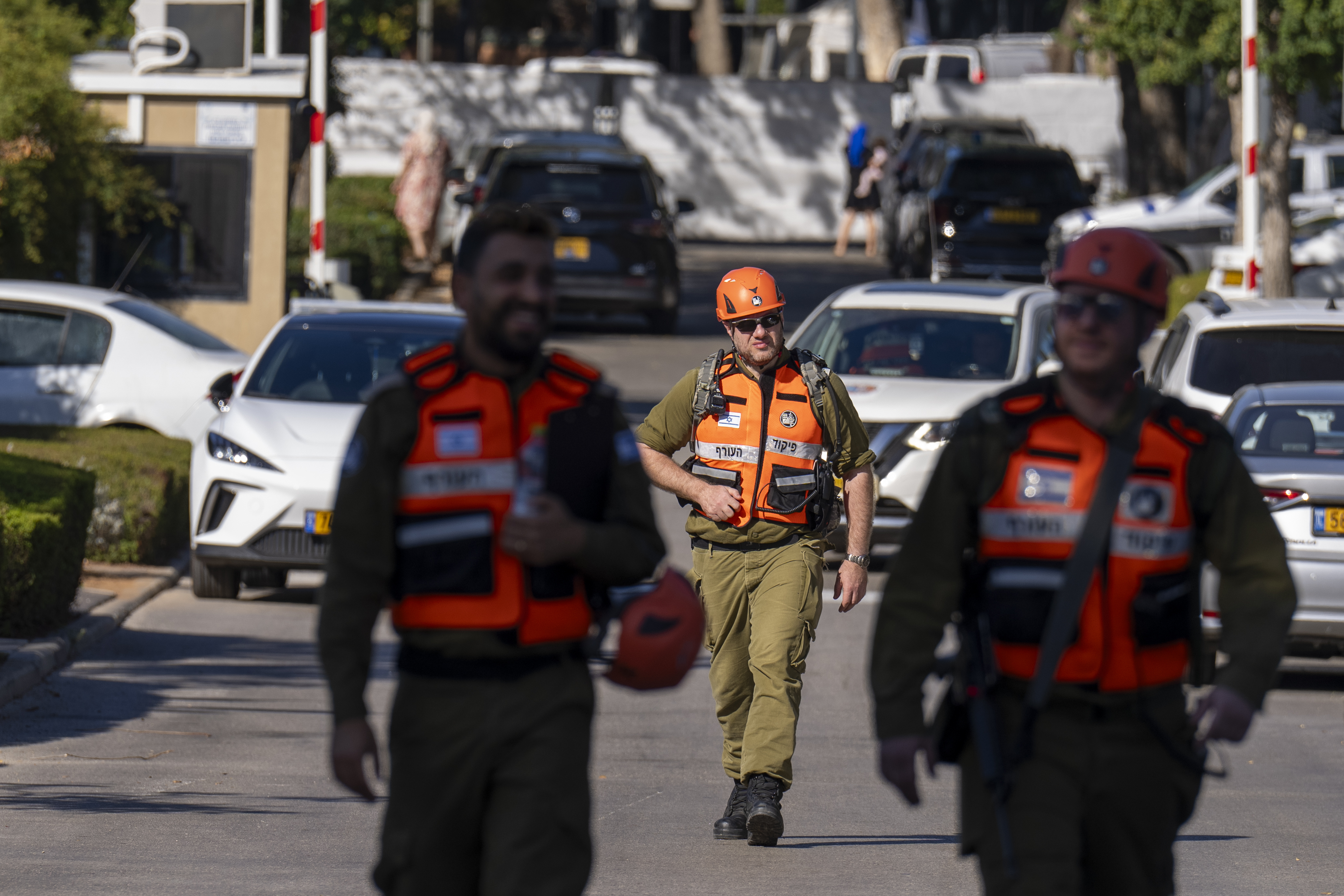Officers from the Israeli Home Front Command military unit walk on a road near where Israel's government says a drone launched toward Israeli Prime Minister Benjamin Netanyahu's house in Caesarea, Israel, Saturday, Oct. 19, 2024. (AP Photo/Ariel Schalit)