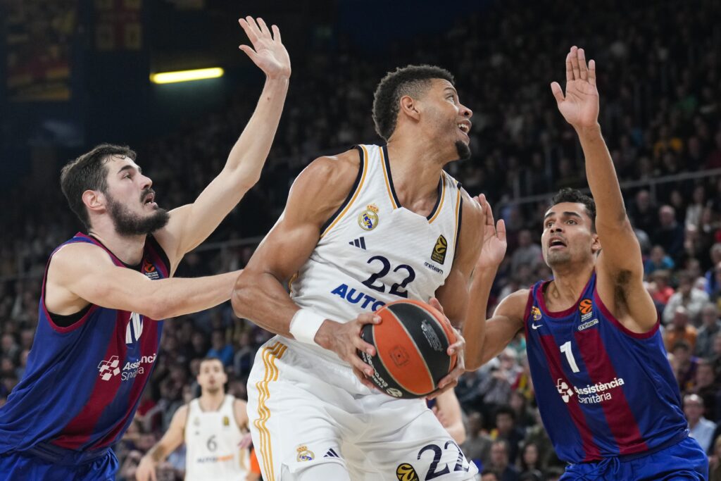 epa11055914 Barca's Nikola Kalinic (L) and Oscar Da Silva (R) in action against Real Madrid's Edy Tavares (C) during the EuroLeague basketball match between Barcelona and Real Madrid, in Barcelona, Spain, 03 January 2024.  EPA-EFE/Alejandro Garcia