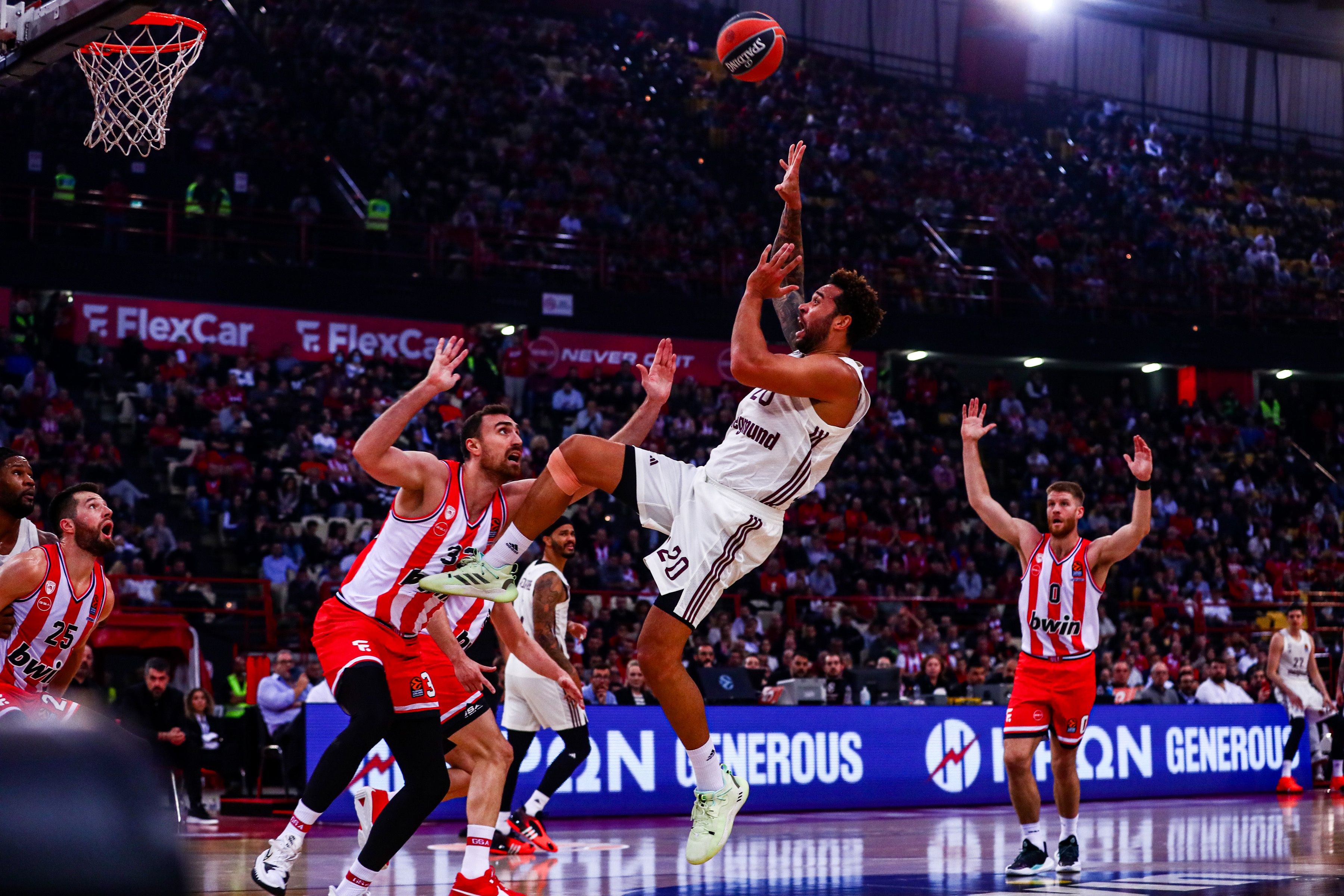 epa11018120 Olympiacos Nikola Milutinov (L) in action against Elias Harris (C) of Bayern Munich during the Euroleague basketball match between Olympiacos Piraeus and Bayern Munich, in Piraeus, Greece, 08 December 2023.  EPA-EFE/GEORGIA PANAGOPOULOU