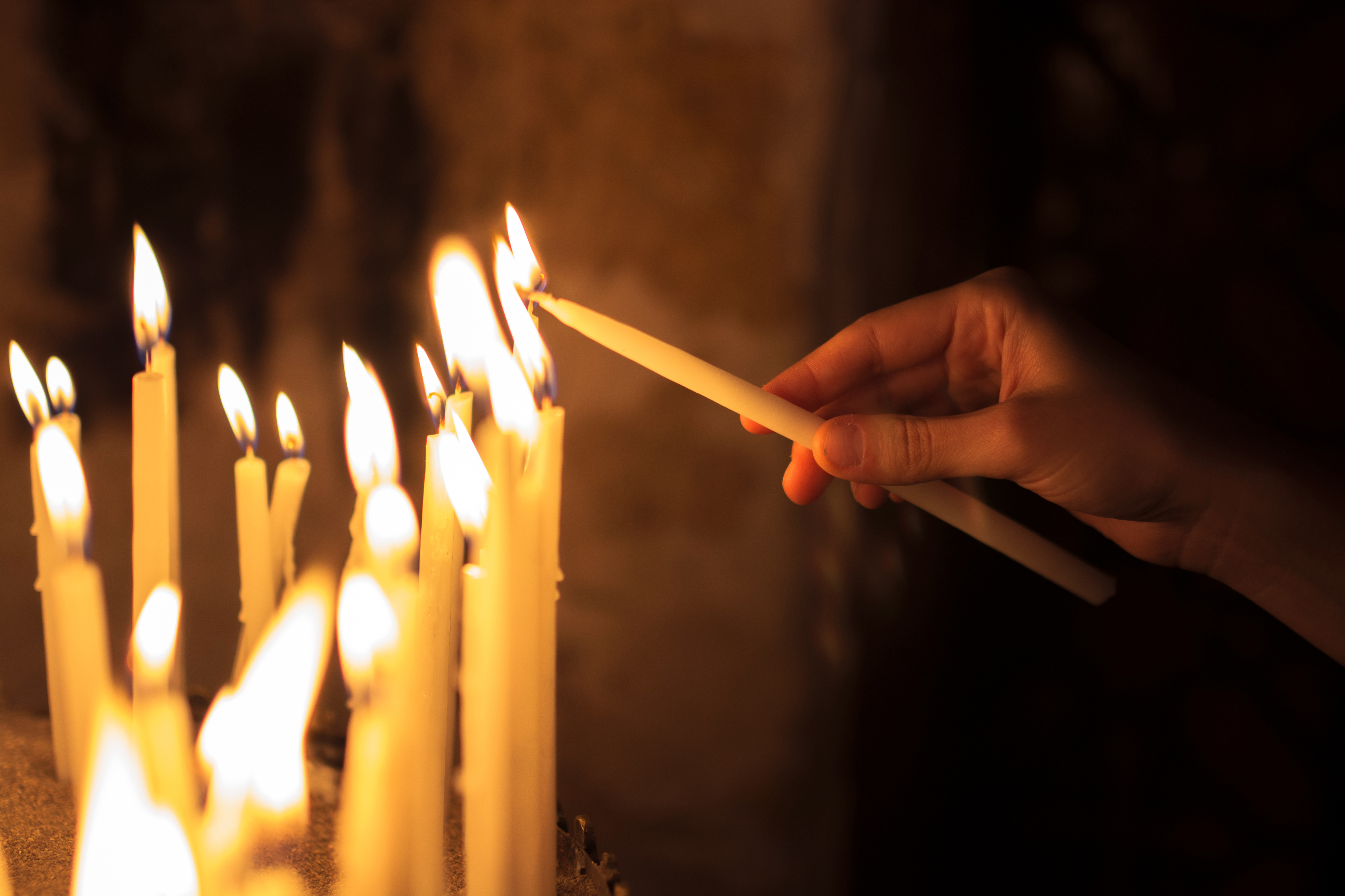 Woman,Lighting,Candles,In,A,Church