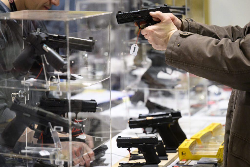 epa11007471 A visitor looks at a gun during the 29th edition of the Lausanne International Arms Exchange, in Lausanne, Switzerland, 02 December 2023.  EPA-EFE/LAURENT GILLIERON