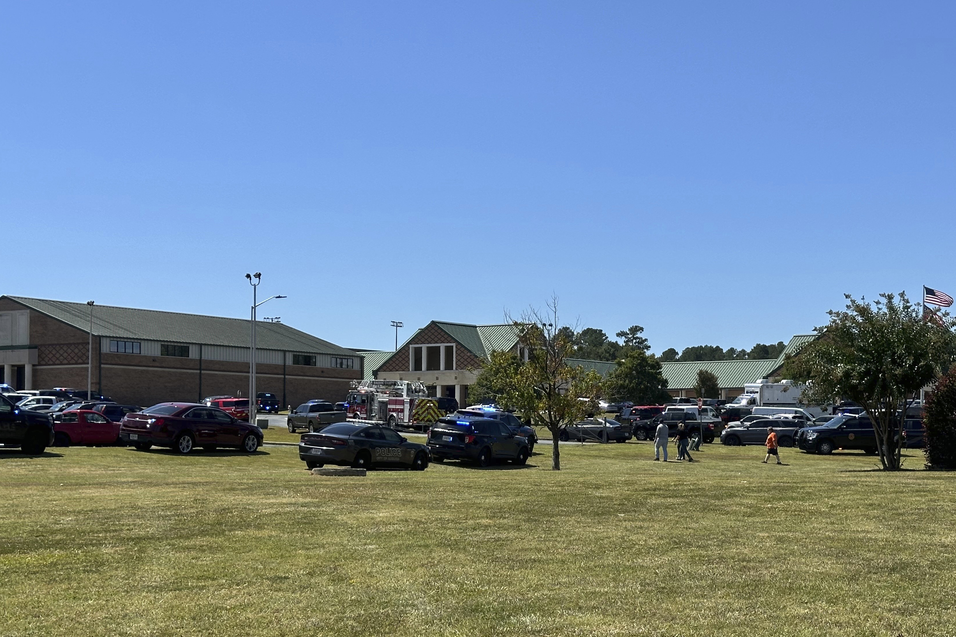 Law enforcement arrive as students are evacuated to the football stadium after the school campus was placed on lockdown at Apalachee High School in Winder, Ga., on Wednesday, Sept. 4, 2024. (AP Photo/Jeff Amy)