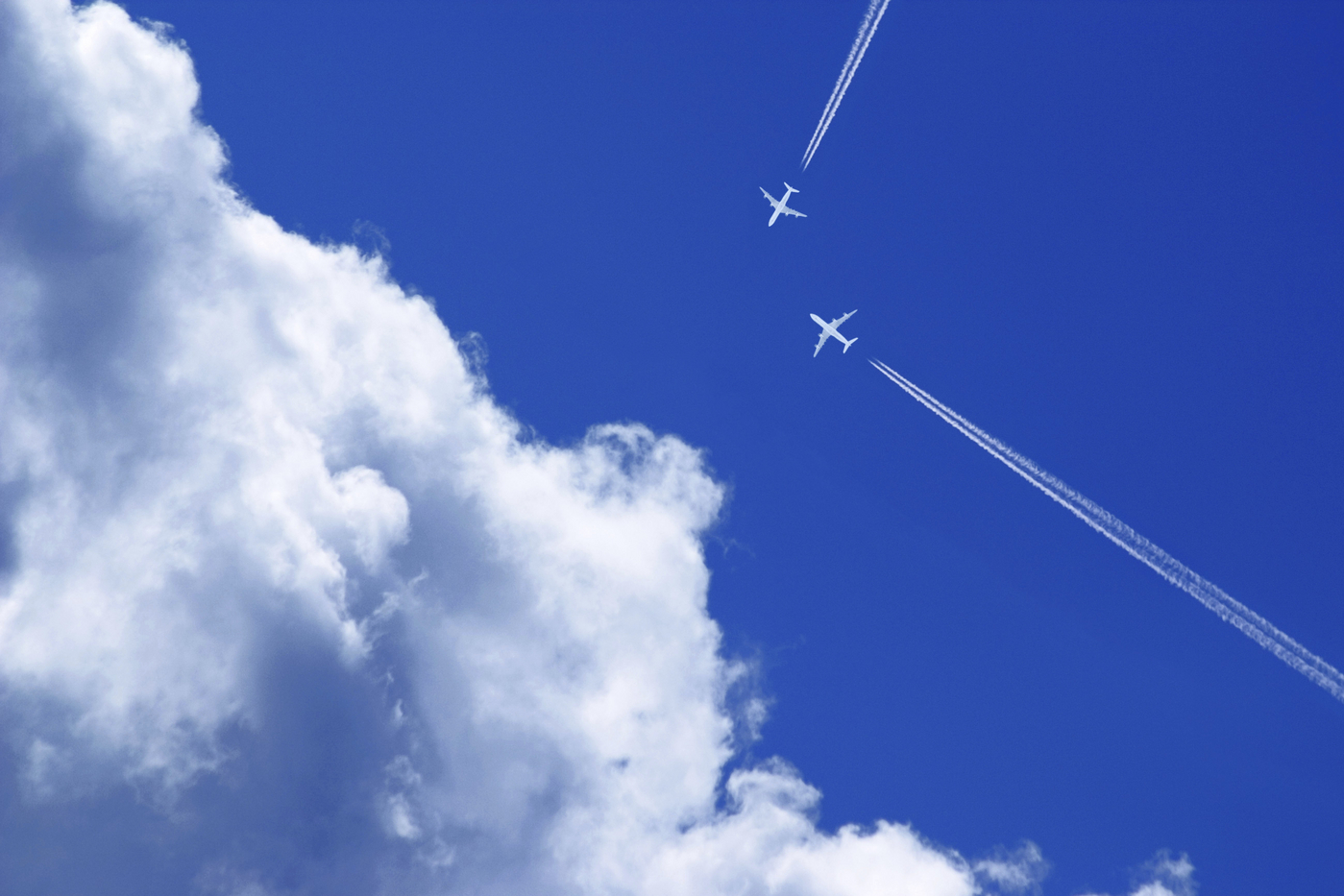 Two passenger airplanes with contrails on a collision course in the blue sky with clouds,Image: 845511322, License: Royalty-free, Restrictions: , Model Release: no, Credit line: Dirk v. Mallinckrodt / imageBROKER / Profimedia