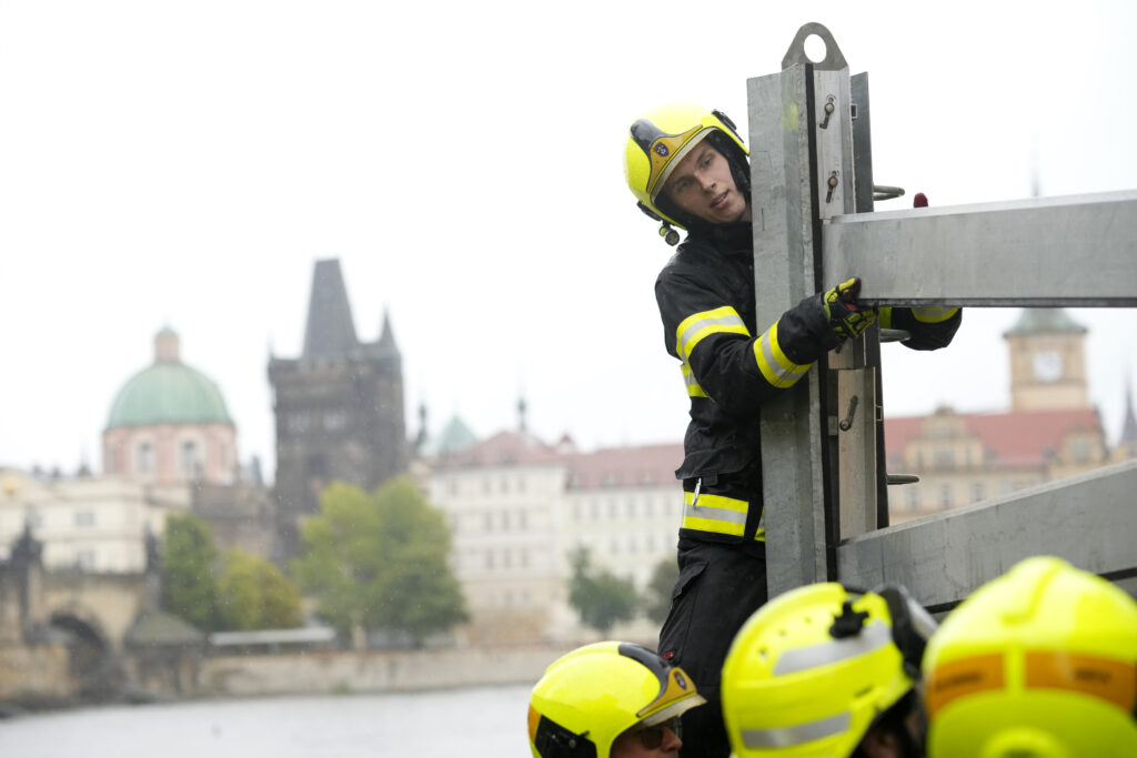 Firefighters adjust parts of the anti-flood barriers in Prague, Czech Republic, Friday, Sept. 13, 2024. (AP Photo/Petr David Josek)