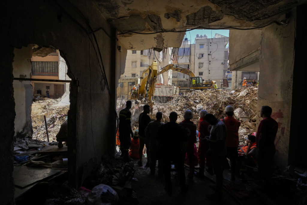 Emergency workers use excavators to clear the rubble at the site of Friday's Israeli strike in Beirut's southern suburbs, Lebanon, Monday, Sept. 23, 2024. (AP Photo/Hassan Ammar)