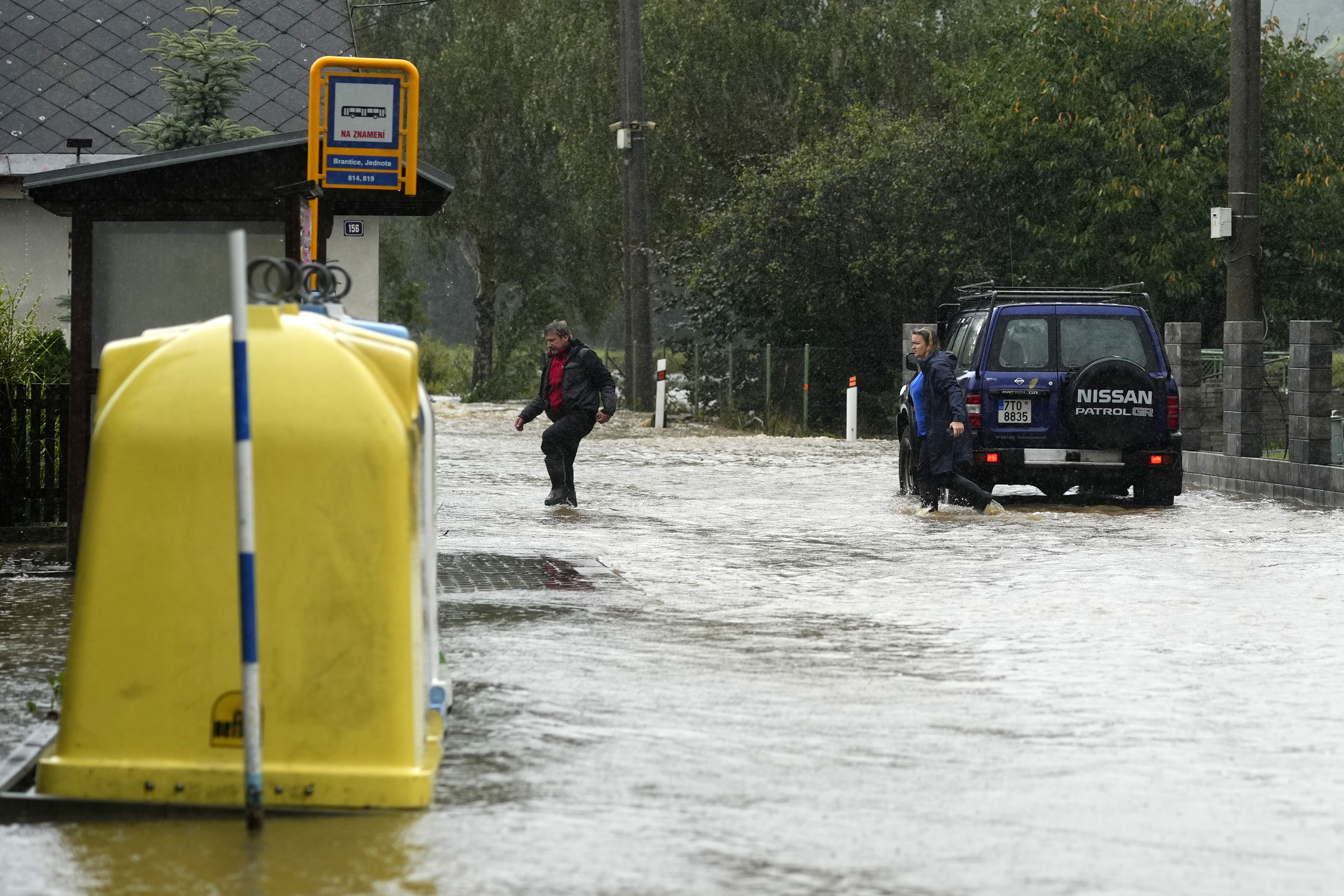 Residents walk to their house through a flooded street in Brantice, Czech Republic, Saturday, Sept. 14, 2024. (AP Photo/Petr David Josek)